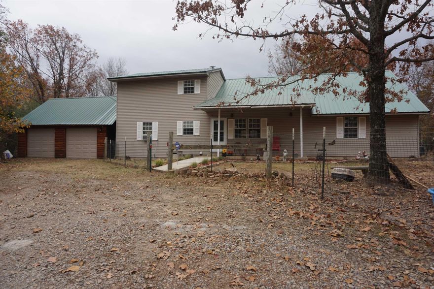 Buyers Contingency fell through so this is Back on the Market So much room both outside and inside. The living room and kitchen are huge and the ceilings are soaring. There are 2 bedrooms and a full bathroom downstairs and a loft on 1 side upstairs, and another huge bedroom with private bath and balcony upstairs. The carpet was installed Nov 2023 and the metal roof is only 3 years old. The heat and air is 5 years old and is on a 2x a year servicing plan with the HVAC company. There is a detached double garage being used for storage with a storm cellar built into the floor. The previous 1 car attached garage is now used as a music room equipped with outlets for the instruments that have their own breaker. There is a heated/cooled dog house and by house, I mean it has a slab floor, metal roof, a window and a doggie door. There is an RV Hookup and a storage building with a lean too on each side.  The metal RV carport cover  does not convey. Minerals are not owned and do not convey. The property is fenced all around with multiple metal gates.