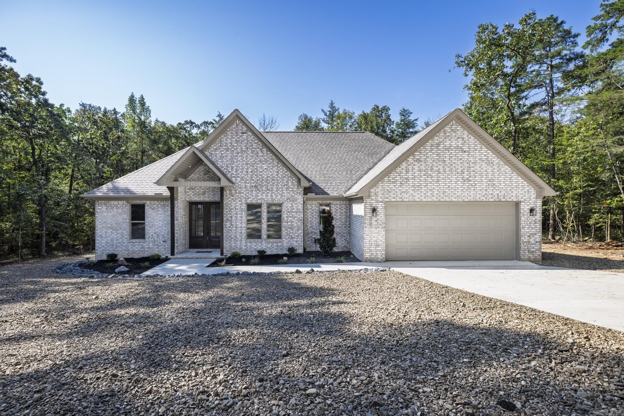 Brand new 1885 square foot home on lovely lot. Trees surround this lovely home with no homes behind. Spacious open floor plan gives you a perfect entertaining area with living, dining and kitchen all connected. You will not be isolated in the kitchen while the family enjoys visiting. Kitchen features a large island and large pantry for your convenience. White cabinetry and counters are an elegant white quartz. Living room opens to a concrete deck perfect for outdoor Village living. Primary bedroom with walk in closet and bath with soaking tub and separate shower. Living area and all bedrooms have a very nice neutral LVP for easy living and low upkeep. Baths feature tile flooring and tub. Three additional bedrooms complete this modern floor plan. Fourth bedroom would make an excellent office or computer room. Taxes are based on vacant lot. Interior pictures are of recent homes completed by builder. Hot Springs Village boasts 9 golf courses, 11 lakes, pickleball, hiking trails, white sand beach, tennis, fitness center and much more. HSV has one time $2000 buy in for new residents.