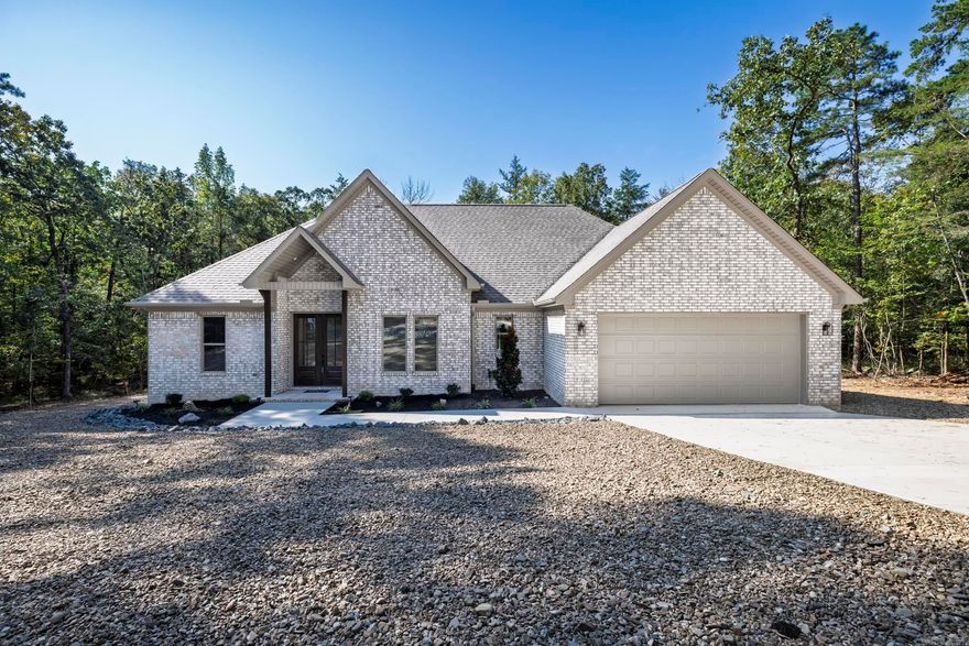 Brand new 1885 square foot home on lovely lot. Trees surround this lovely home with no homes behind. Spacious open floor plan gives you a perfect entertaining area with living, dining and kitchen all connected. You will not be isolated in the kitchen while the family enjoys visiting. Kitchen features a large island and large pantry for your convenience. White cabinetry and counters are an elegant white quartz. Living room opens to a concrete deck perfect for outdoor Village living. Primary bedroom with walk in closet and bath with soaking tub and separate shower. Living area and all bedrooms have a very nice neutral LVP for easy living and low upkeep. Baths feature tile flooring and tub. Three additional bedrooms complete this modern floor plan. Fourth bedroom would make an excellent office or computer room. Taxes are based on vacant lot. Interior pictures are of recent homes completed by builder. Hot Springs Village boasts 9 golf courses, 11 lakes, pickleball, hiking trails, white sand beach, tennis, fitness center and much more. HSV has one time $2000 buy in for new residents.