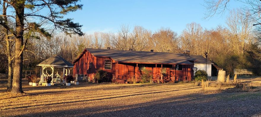 GORGEOUS SUNSET VIEWS from this property that includes two parcels for a total of 4 acres. A couple of additions to the single wide mobile home provide a living area with hardwood floors and front porch to enjoy the awesome sunsets, while the rear addition consists of a den with built-ins and a second full bath. The stackable washing machine and dryer unit is currently located in the main bathroom, but the laundry could easily be relocated to the enclosed storage off the hallway where hook-ups are already in place. In addition to the peaceful setting, a spacious shop, in-ground storm shelter, gazebo, and lots of lovely flowers round out the exterior features of this property. The roof on the home was replaced in January 2024 and the septic was cleaned less than 2 years ago. Just 12 mins to Riverside Park, 15 mins to Harding University, and 20 mins to Wal-Mart. *The wood-burning stove in the living room works, but the chimney can't be used.