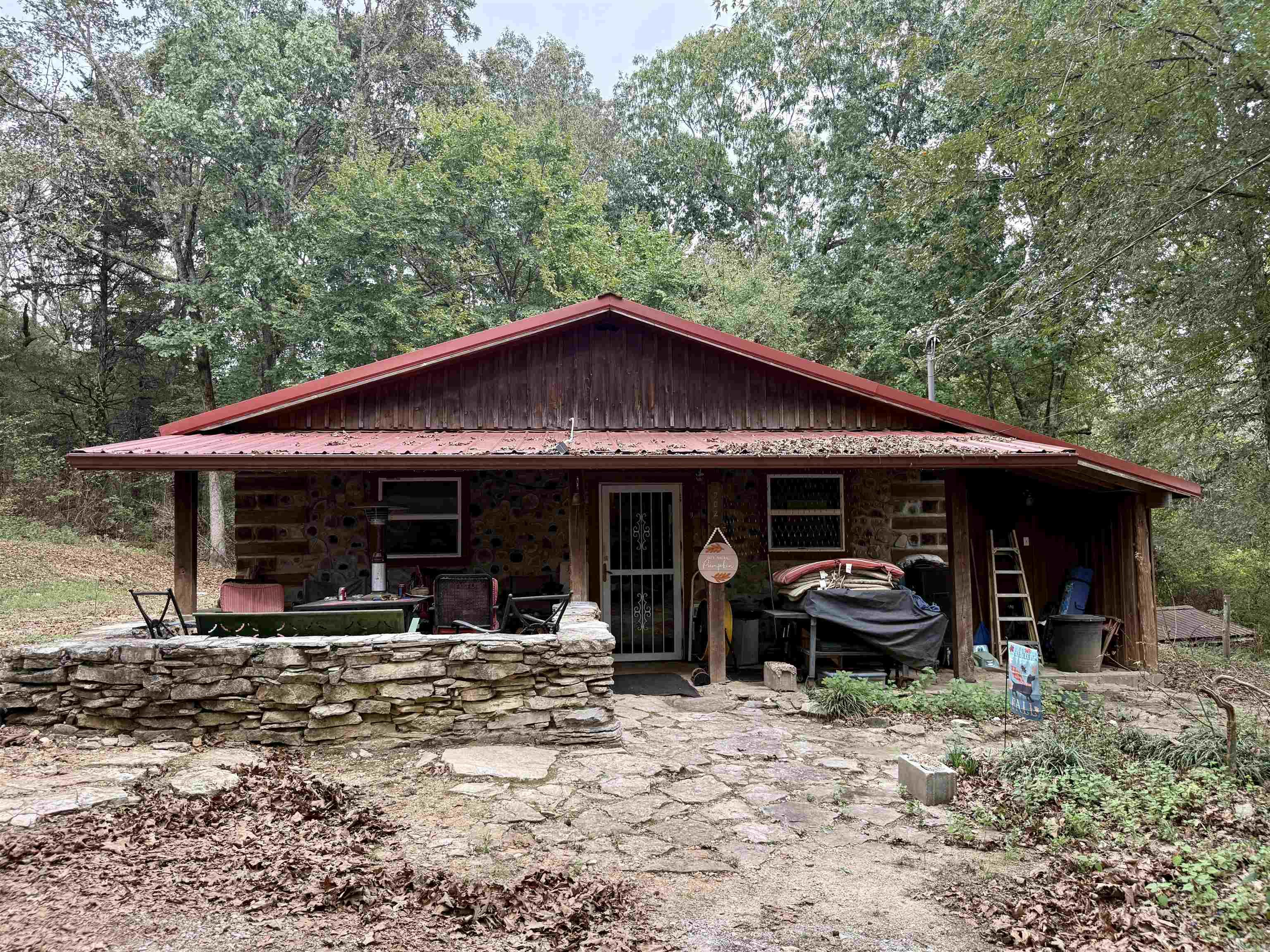 Escape to your own rustic retreat on 20 beautiful acres! This handcrafted Cedar Cordwood-style home exudes character with 16'' exterior walls and walkways made from rocks harvested right off the land. Inside, you'll find 2-3 bedrooms, 2 baths, an Amish-built kitchen, rock and laminate flooring, wood heat stove, and Senville mini-split units (2024). Outside offers space to breathe with a -acre pond, storm/root/wine cellar, 20x30 wired shop with deck, 18x20 guest house with kitchenette, storage building, and more. Roof replaced 2019/2020, propane tank leased and filled Aug 2025, and Clay Co Connect fiber internet available. Refrigerator stays, and home will be professionally cleaned after move-out. A true blend of craftsmanship, comfort, and country serenity!
