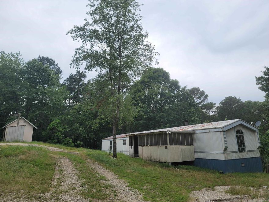 Handyman Special! This 3/2 singlewide mobile home sits on almost 4 acres and has a bonus storm shelter. It also has a large out building for storage and a large enclosed porch. The home features an open concept with a large kitchen, huge island bar and a fireplace. The bedrooms are spacious with the master having a separate vanity table area and a garden tub. This home needs some TLC but wont break the bank. Schedule today for your tour. It would make a great rental or a nice beginner home.