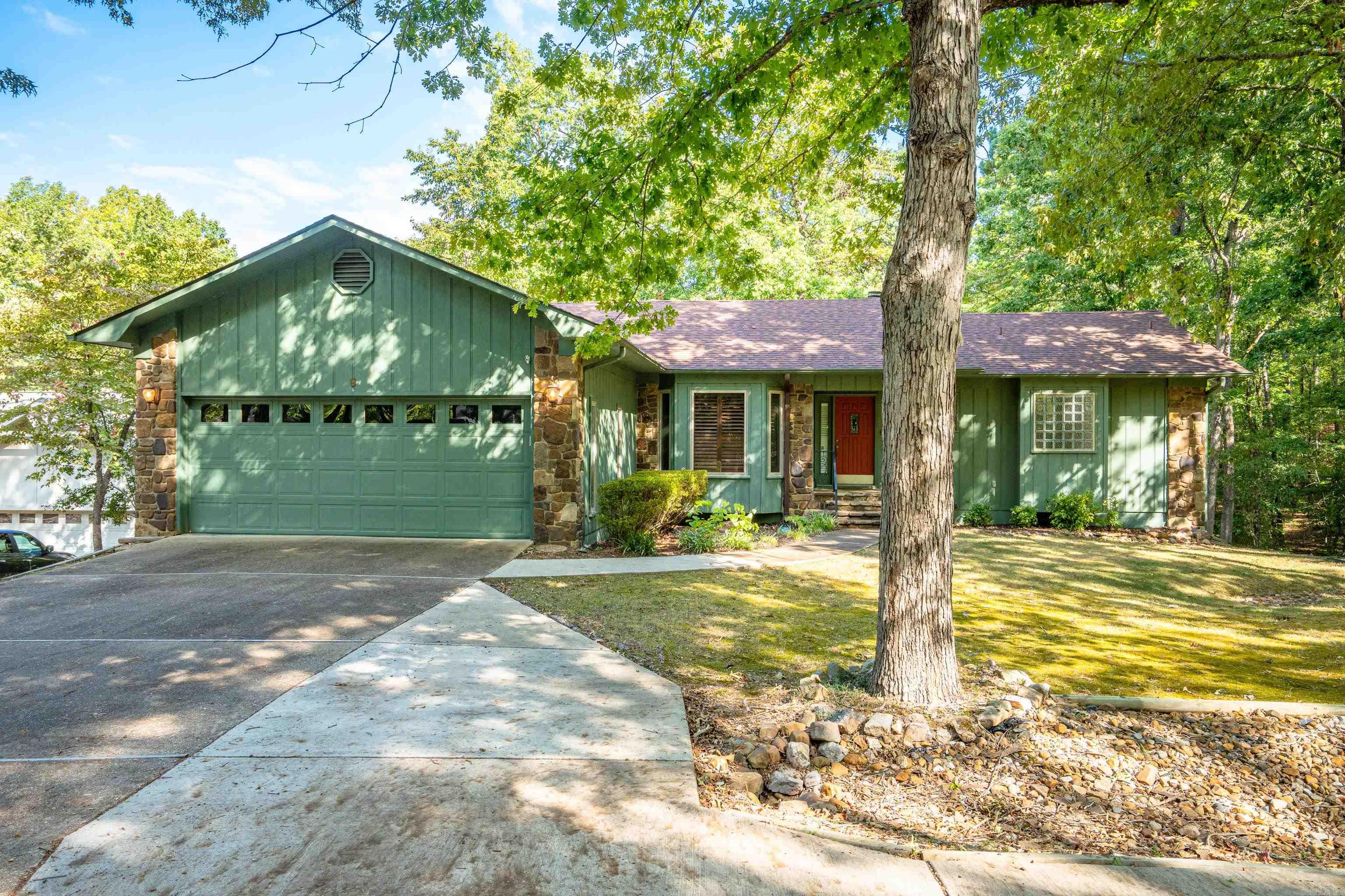 This spacious home has lots of room for the entire family! Enjoy your views of Lake Cortez from all rear windows from this home as you sit out on your enclosed deck or in the inviting sunroom. There is a large eat in kitchen with dining area as well. Beautiful woodburning fireplace with shelving. Master bedroom upstairs w/jetted bath and separate shower with adjacent half bath and large closet. 2 more bedrooms and a bunk room downstairs with a full bath, wet bar and mini fridge for extended guests. Large laundry room with folding area and built in ironing board. Stone tile floors throughout with the exception of primary and living room.Custom fitted carpet in 2 rooms that can easily be removed. Lots of storage with this gem, including under stairs, safe room, large cabinets in garage and storage for yard equipment. With a convenient oversized flat driveway you will have room for your guests with an additional parking pad. New roof 2019, 2021 water heater, 2023 upstairs HVAC and 2024 downstairs HVAC. 1500.00 one time membership fee for future owners of Hot Springs Village.