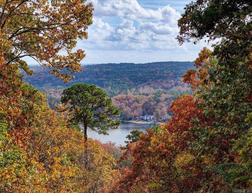 Lake Cortez & Mountain Views • Vaulted Ceilings • Arkansas Room • Treetop Setting  Fantastic hilltop home in a quiet cul-de-sac with beautiful views of Lake Cortez, the golf course, and surrounding mountains. The main living and dining areas feature tall vaulted ceilings and large windows that fill the space with natural light. The bright kitchen offers wood flooring and easy access to the living areas.  An inviting Arkansas Room with abundant windows showcases the scenic views, while a separate office with built-in cabinetry can serve as a third bedroom. The spacious primary suite includes a vaulted ceiling, walk-in closet, and bath with soaking tub and walk-in shower.  The walk-out basement level provides an additional living area, bedroom, and full bath with walk-in shower—ideal for guests or rental opportunities. A large deck spans the back of the home, offering wonderful outdoor living and a treetop feel overlooking the lake and mountains.  Located in Hot Springs Village, residents enjoy lakes, golf, pickleball, trails, a community center, fitness facilities, dining, and more.  Add your finishing touches to make this home your own!