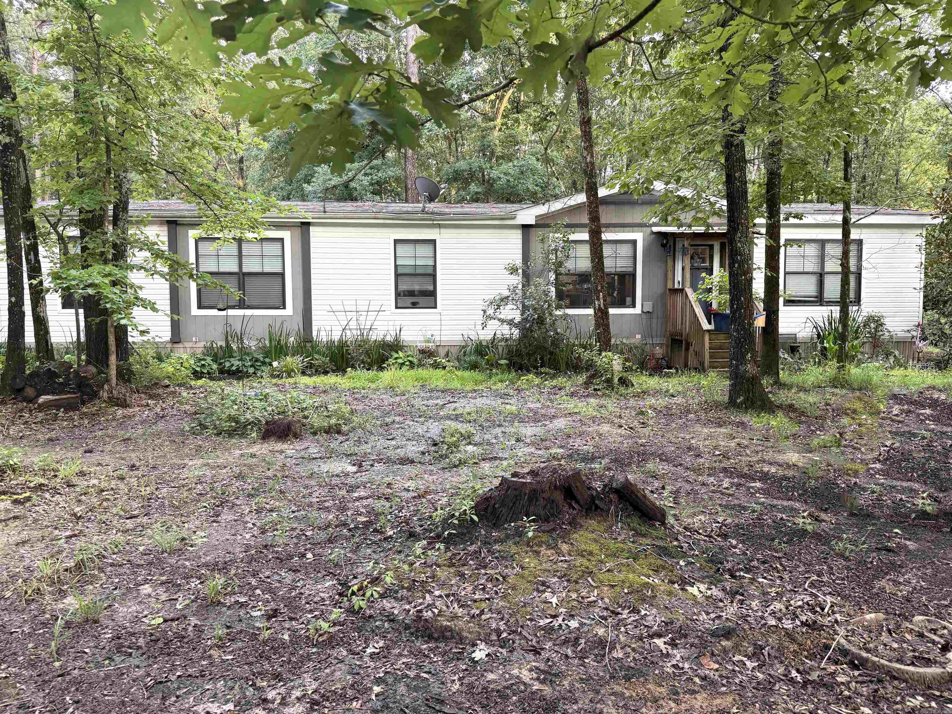 Welcome to your dream mini-farm on 7 beautiful acres just minutes from Sheridan and I-530! This 4BR/2BA, 1,904 sq ft 2019 manufactured home on a permanent foundation offers an open layout perfect for family living. The property features multiple outbuildings—including an 11x30 wooden-floored shop with loft storage—plus a three-part barn, chicken coop, greenhouse, high tunnel, and a concrete-floored shed. A large pond, fenced pasture, RV/boat cover, and a new three-part carport with enclosed shed make this property ideal for livestock, gardening, or hobby farming. Enjoy mature Muscadine vines, blueberries, heritage flowers, and scenic country privacy with modern comforts. An older fixer-upper home on the property adds even more potential. Fully fenced backyard, RV hookups, and ample space for expansion or subdivision. Whether you're looking to homestead, raise animals, or just enjoy peaceful country living, this property is ready for you!