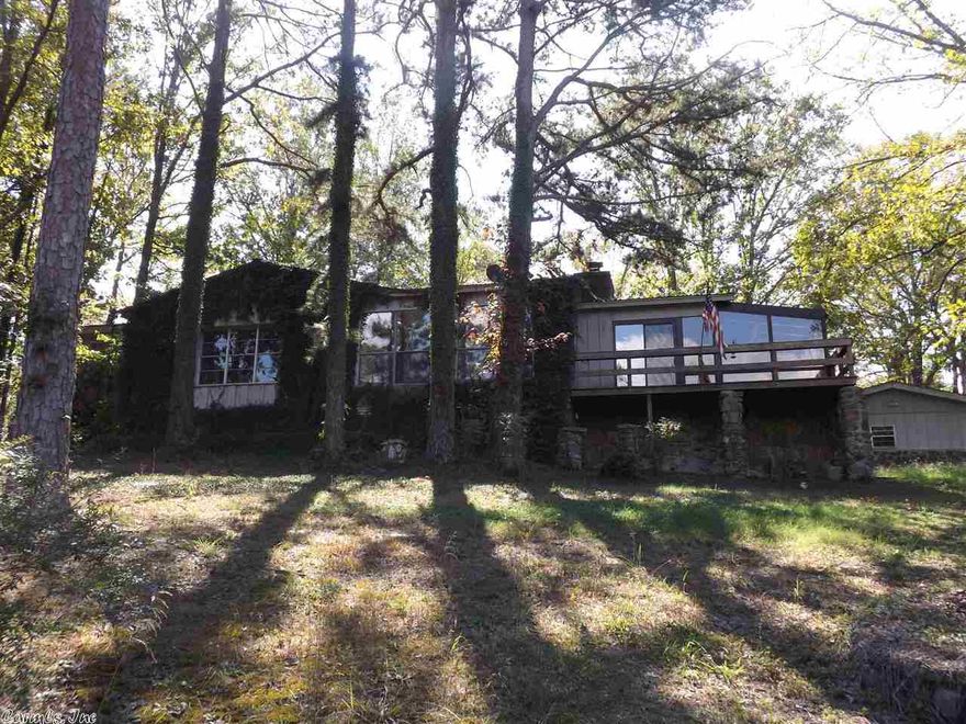 WOW! WHAT A PACKAGE DEAL!  Home, Shop Building, Garage, Pole Barn,  Mobile Home (Guest House), and 6 Lots, Plenty of space to expand.  Wood and Rock Rustic style home is 2 bedrooms, 2 and 1/2 baths, Master is large with vaulted ceilings, Open Kitchen living area, rock fireplace, windows for lake view. Spacious kitchen ,room for all to cook together, Island has a cooktop, with grill. Frig stays too. Large open sunroom. Mobile Home has 2 bedrooms and 1 bath, mostly furnished and ready for guest. Must See!