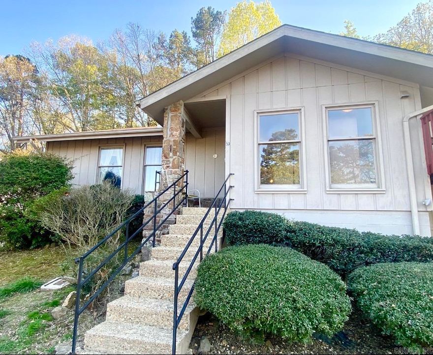 Welcome to this charming one story three-bedroom townhouse in desirable Valencia Courts on the west end of Hot Springs VIllage. Outdoor stairs lead to the cozy front porch and welcoming entry to the home with lots of natural light. The wide front hall leads to the cute kitchen and a great dining and living space with enough room to add a desk or a yoga mat. The living room has a beautifu sliding door leading to the private wooded view in the back. Another hallway leads back to the nice-sized three bedrooms with a full bath along the way. The primary bedroom offers a nice wooded view, and has its own en-suite with a sink and toilet. When you use the large sliding door in the living room to go outside, you'll be wowed by the huge private patio on the back, and the long range wooded view is so peaceful and lush. The back also offers an ample storage space that can be locked to store your bikes or extra's. Having a new roof is an added bonus   as well as this being an end unit, offering lots of privacy. A nice-sized laundry room makes this townhouse complete.  Hot Springs Village is a gated community with golf and lakes galore.  A One time $2,000 buy-in fee is required.