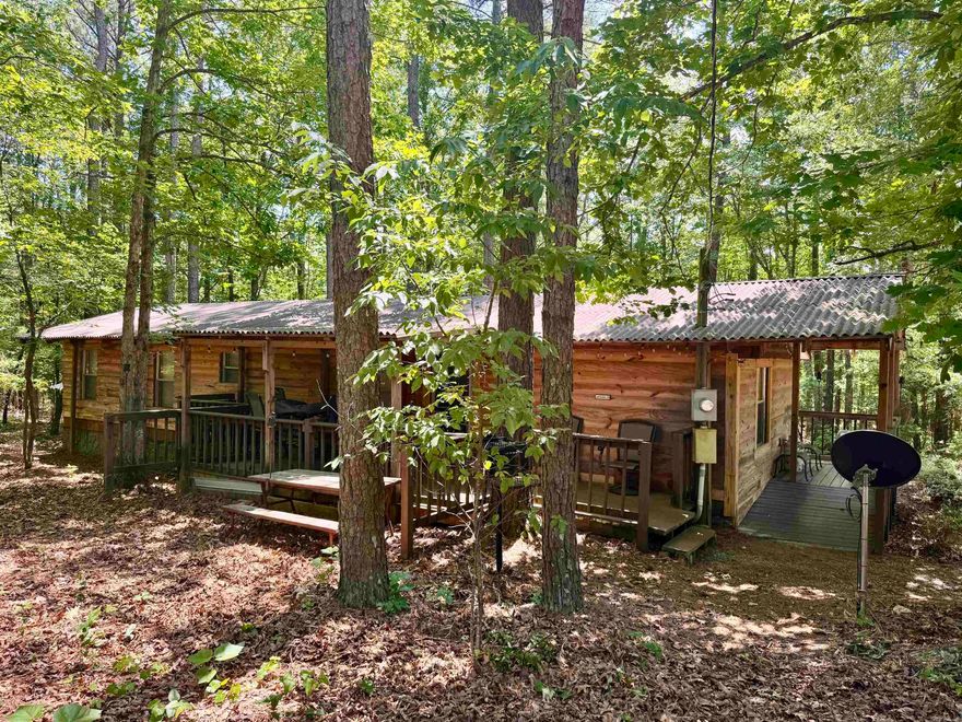 So many opportunities with these two dwellings in a beautiful natural setting. The 904 sq' mobile 3/2 home has been completely renovated inside and out. You would even know it's an MH. The 540 sq ft 1-bed 1-bath tiny home has been built to the same high-quality standards. These units have been used as short-term rentals and have a wonderful rental history.  They are being separated from Knotty & Nice cabin rentals, which all used one water source. A well will need to be installed. Seller will allow water to be used from their well for 30 days after closing to allow time to have this done. Each unit has its own septic system. Each unit has its own hot tub. Taxes will need to be figured separately from the entire complex, so the listing is not accurate there. Acreage will be adjusted on listing once the survey is completed.