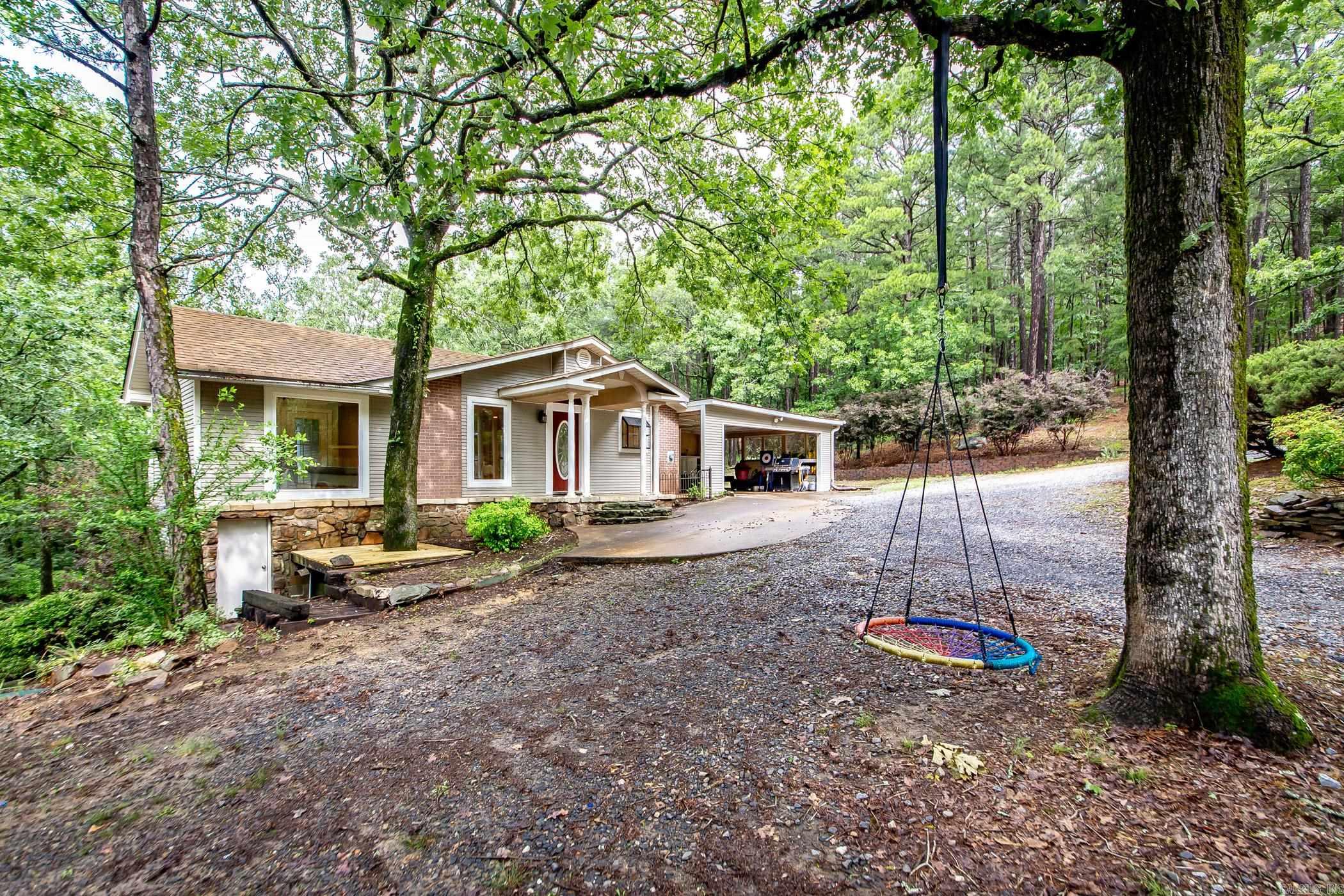 With the unbelievable combination of privacy, nature, and fresh updates, it’s no wonder this home is located on the aptly named Unicorn Lane. Welcome to 21221 Unicorn Lane, this private property spans over an acre, and yet, it’s only a short distance to Pinnacle Mtn and an 8 min drive to Walmart. The wooded land next door is owned by CAW so you can rest easy knowing the only neighbors you have to the right will be an abundance of deer and other wildlife. Once inside, you will find an open floor plan with an amazing kitchen renovated with function and entertaining in mind. Stay organized with two pantries and large laundry room with built-in storage. The oversized primary bedroom features a walk-in closet and separate back deck overlook the backyard oasis. On the main level, there are also two additional bedrooms, one with a half bath, and access to the full bath in the hallway. Downstairs is a large bonus room/ fourth bedroom with a mini-split and backyard access. To the left of the house is a large shop that has spray foam insulation, ample workspace and even more storage. Located behind the shop is fenced horse corral. Agents see remarks