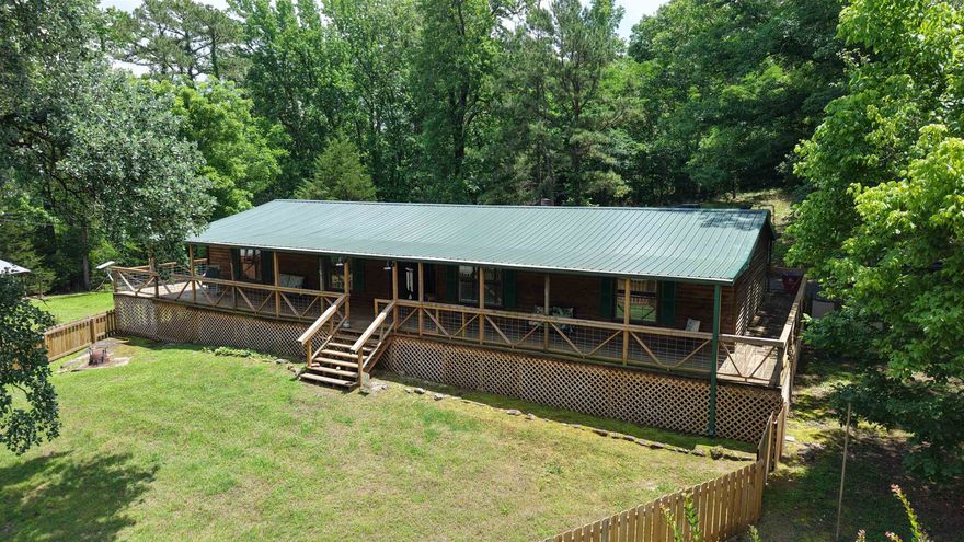 Remodeled Log-Style Home on 3 Acres This remodeled 3 bedroom, 2 bath log-style modular home is situated on 3 acres in Mount Pleasant, Arkansas. Listed at $249,900, the property offers 1,960 sq. ft. of living space in an Ozark setting. Energy efficiency upgrades include extra insulation throughout, additional floor vent insulation, central heat and air, propane fireplace, propane stove, and propane hot water heater. The home features new gutters, internet wiring, custom walk-in closets, and a wrap-around porch for outdoor lounging. The property includes a new metal roof, septic system, and private well with a heated well house. An insulated shop with electric service offers workspace for projects or storage needs. A 20x40 RV cover features 30-amp hookups and 13-foot height clearance. A Conex trailer conveys with the property. This move-in-ready country home combines modern updates with rural living in an Ozark setting. Listed for $249,900.