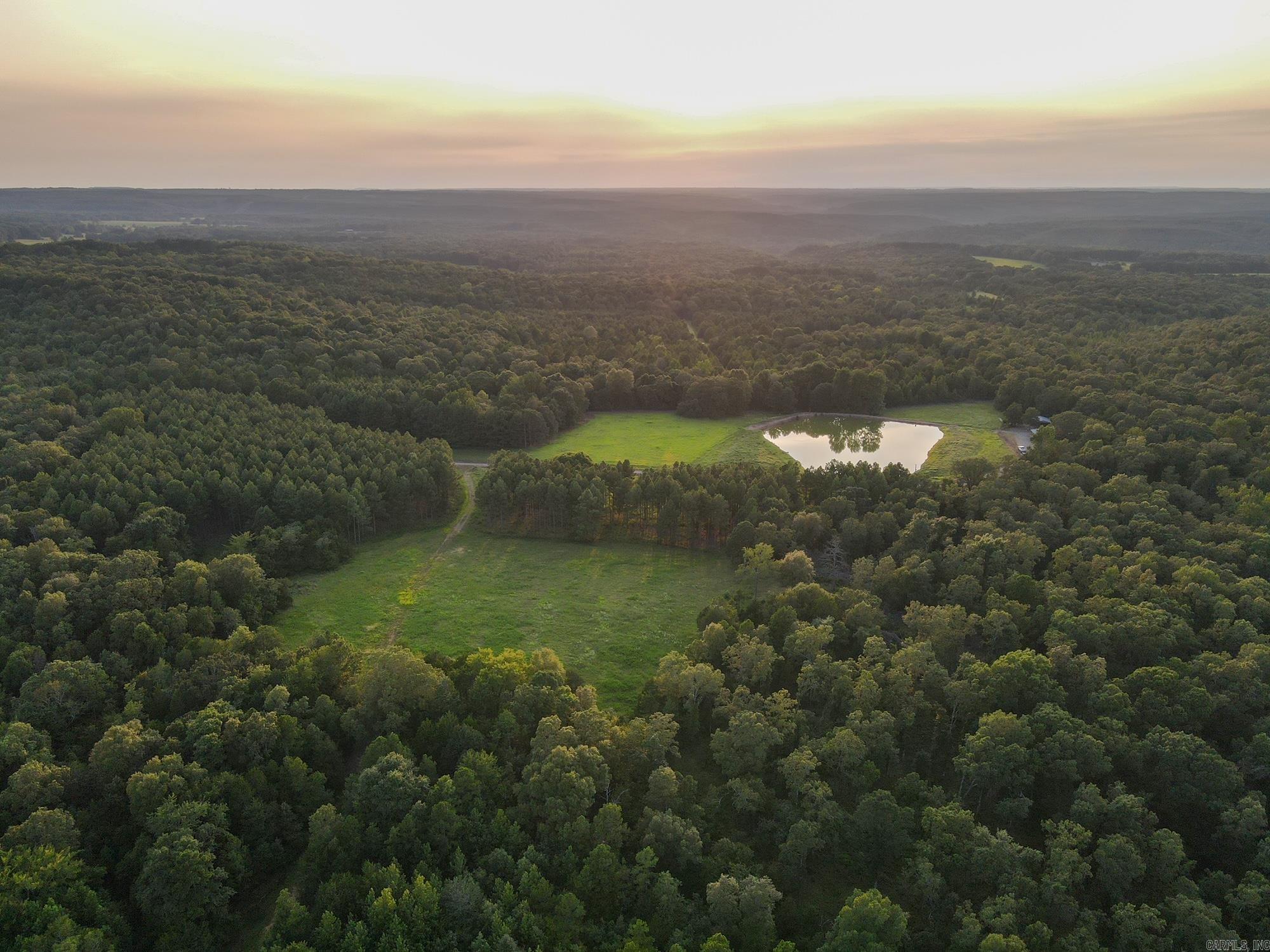 Discover the ultimate wildlife management property with 2 miles of high fencing around 157 acres, perfect for growing trophy whitetails with native genetics. Enjoy hunting on-site with bucks reaching 180" or explore the 73 acres outside the fence for fair chase opportunities. Black bears occasionally visit, adding to the adventure. Property also boast incredible turkey hunting. Deer stands and feeders convey. There is an excellent road system throughout the property making travel and maintenance a breeze. For those interested in livestock, nearly 57 acres of pasture and clearcut land are available. The property features 3 stocked ponds and Mill Branch for year-round water. Ideal for hunters and ranchers alike! 1,344 +/- sqft lodge on the property that conveys fully furnished. 3 bedrooms and one full bath plus a large, skinning shop with refrigerators and freezers included. Minerals do convey.