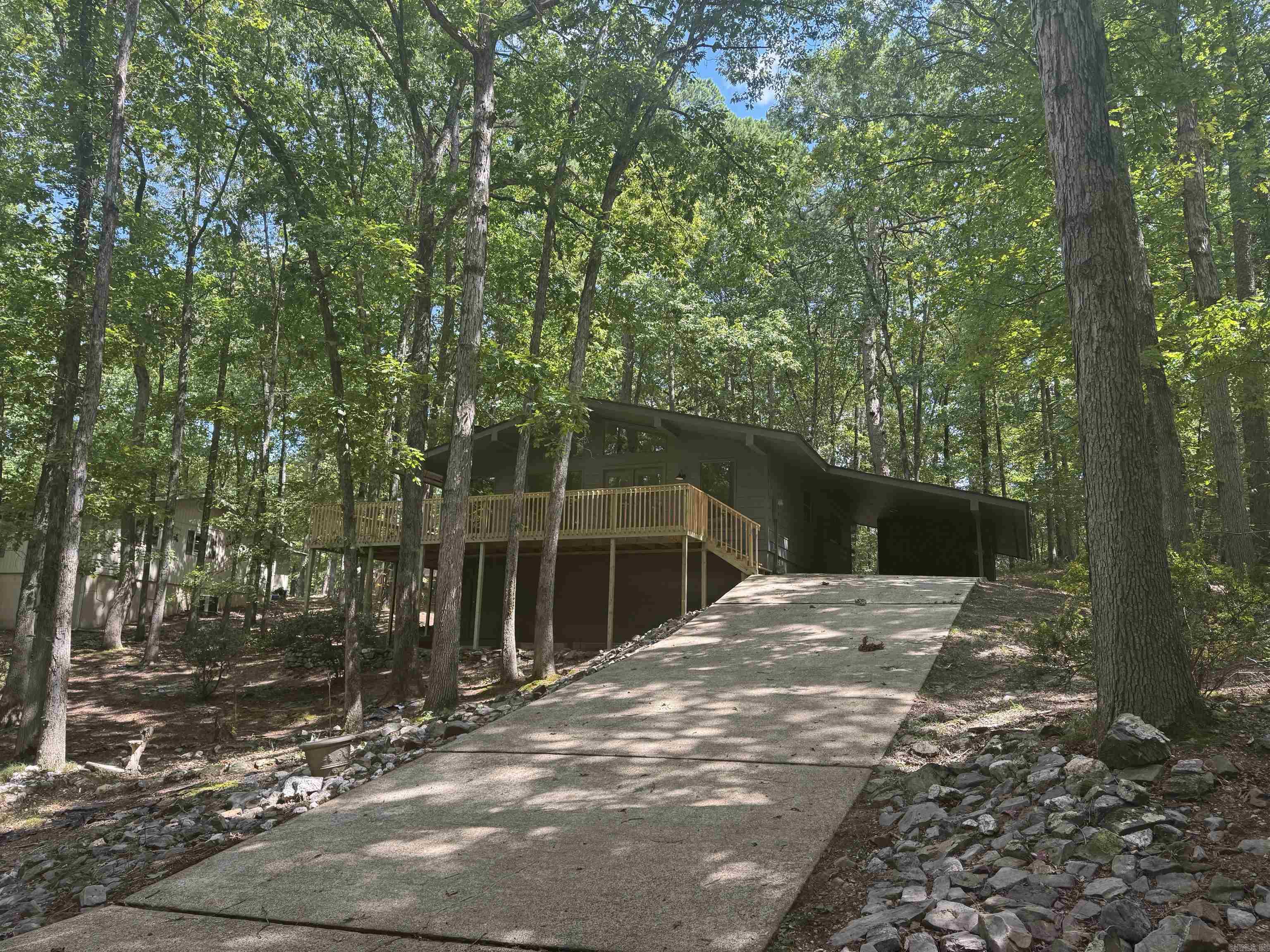 UPDATED: 2 bed 2 bath plus office. New roof, flooring, cabinets, leathered granite countertops, paint in & out, LED lights & fans, SS appliances. Single carport with extra storage. Super cute & ready to move in. All electric. Nice trees. Huge wrap around deck, feels like you're in a tree house. Very cool vaulted ceilings with high windows. Light comes in but trees keep it shaded. Huge under house storage. Hot Springs Village is a large private gated community with all kinds of amenities: clubhouse, golf courses, tennis, pickleball, swimming pool, lakes, marina, restaurants, walking trails, farmer's market, etc. Possible 100% USDA RD financing. SEE AGENT REMARKS FOR OFFER SUBMISSION INFO.