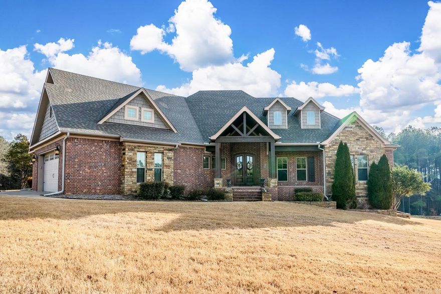 This custom built home is a masterpiece of design and craftsmanship, on a 1.49 acre lot backing up to a serene wooded area. With 4 beds (3 down 1 up), bonus and 4 full baths (3 down 1 up) spread over 3,445 square feet. The split floorplan provides flexibility and privacy for everyone. Notice the elegant interior, where luxury vinyl plank flooring, tall ceilings & exquisite wood trim create an atmosphere of sophistication. The gourmet kitchen is a chef’s dream, w/ granite countertops, huge island & lots of cabinets and counterspace. Entertain guests in the separate dining room, which can also serve as a home office. Cozy up by the fireplace in the large living room, or retreat to the primary suite, w/ a vaulted ceiling & luxurious bathroom that includes a fireplace, soaking tub & separate tiled shower. Outside, you’ll find covered front and back porches, perfect for enjoying the tranquil surroundings and outdoor living. Additionally, the 3 car garage provides ample parking and storage space, the safe room provides peace of mind during inclement weather.  Located in the top-rated Greenbrier school district, don’t miss the opportunity to make this house your home! Agents see remarks.