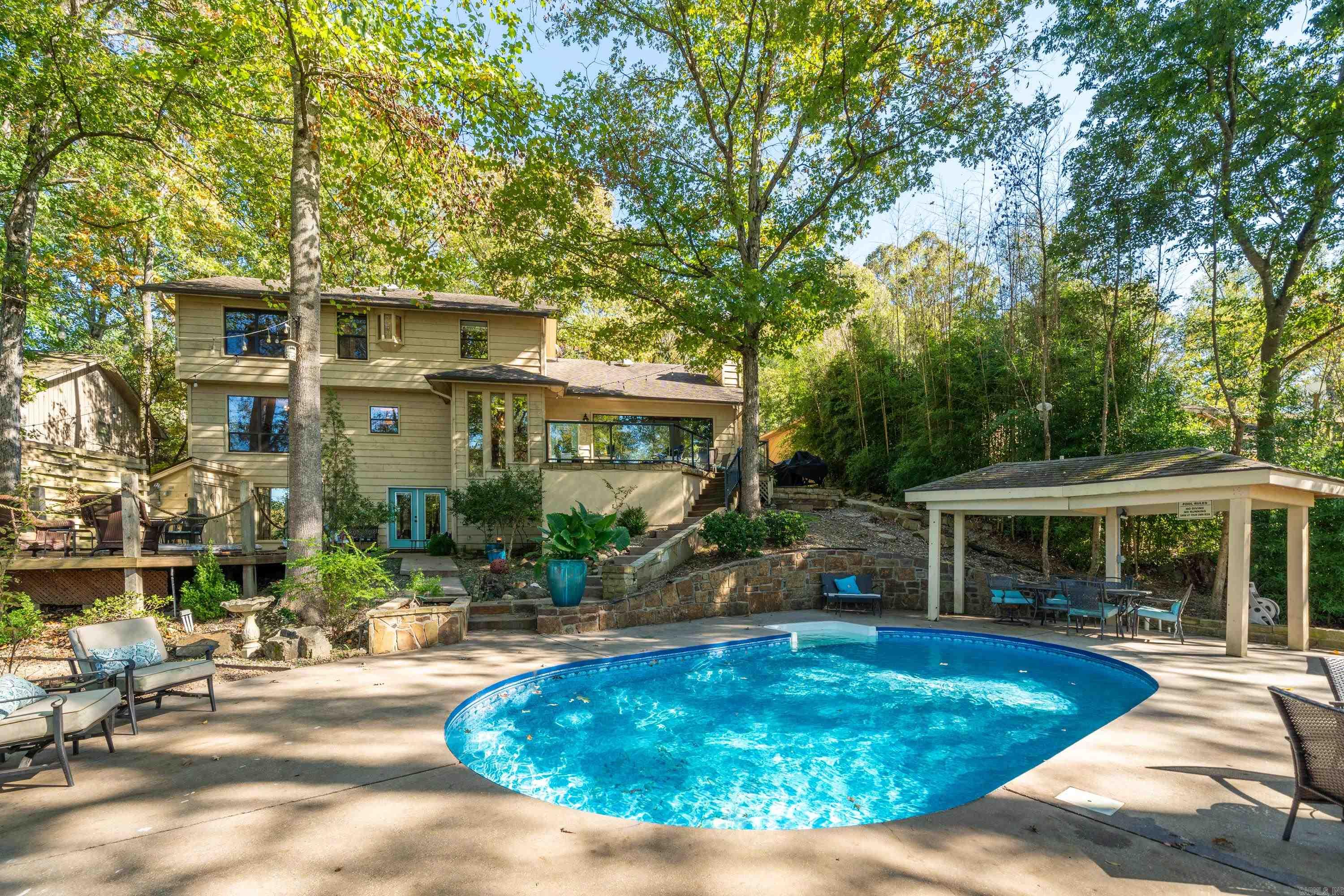 Welcome to Lake Hamilton living and experience the ultimate natural park environment in your own back yard! This property is perfectly situated with a relaxed, cozy setting on the lake. It has a well-blended balance of privacy and expansive views of the lake. The rare find of green lawn stretching from poolside to water's edge, shaded with mature trees, showcase the natural beauty of Hot Springs National Park. Pool, hot tub, and sauna lends to an amazing entertainment setting! Inside the home, featuring multi-levels and separate living areas, the ease of relaxed lakelife continues. View this beautiful home well-suited for family or rental property. Double boat dock and swim platform.