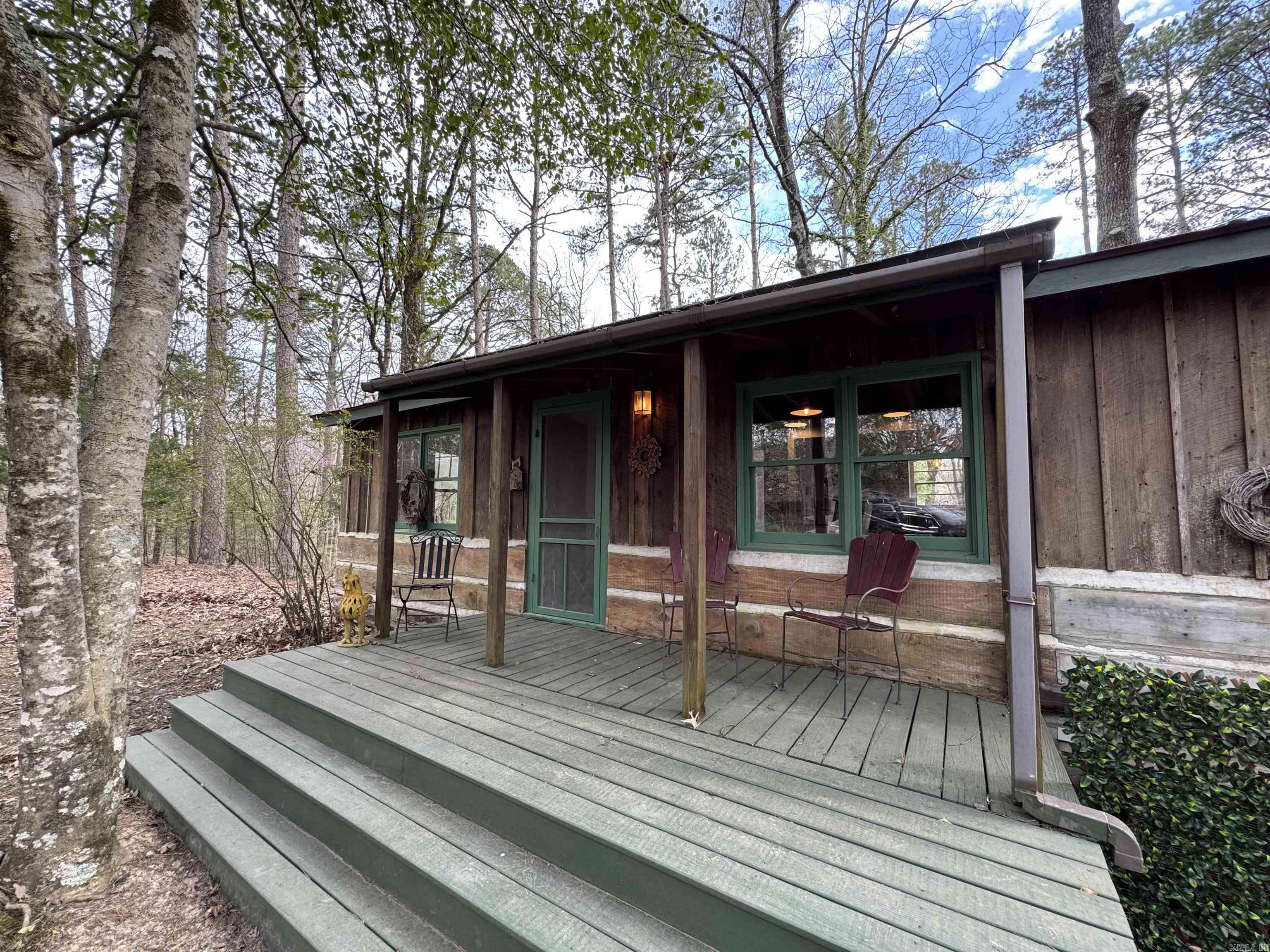 One of those Rare times in life a great cabin near Ouachita comes along. This one is minutes from Shangri-La resort with popular restaurant & marina, Ouachita Vista Trail & Denby Bay trailhead access. This place has never sold on the open market and has been in the family for generations. Under roof is 1986sqft consisting of 2 cabins(2 bed/1bath w/ full kitchen & 1bed/1bath w/ kitchen stub out) connected by screened porch breezeway, carport/patio & porch. Newer stove, water heater, mini-splits, refrigerator, deck, paint, plumbing and electrical upgrades. Out building for extra storage. Ample space to park boats & store lake toys in the off season. It would likely be possible to have RV parking as well. Vacation Rental income option. Updated for today's comforts. Tranquil cabin in the woods for a place to drop your bags and enjoy all that Ouachita offers or call it your main home. Surveillance system does not convey but absolute solitude is included.