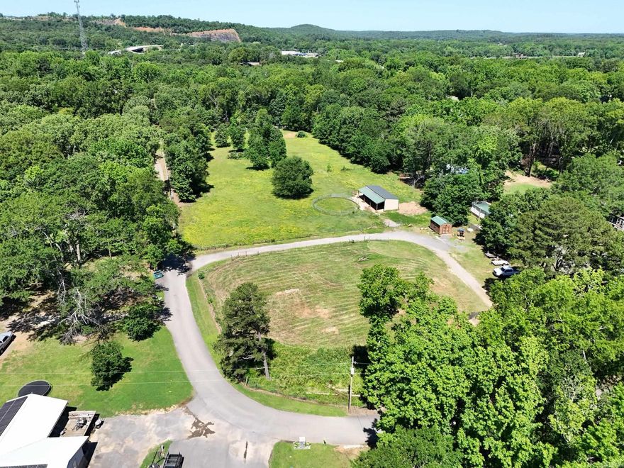 3.8 useable acres, pull through drive, fenced, electric on the property.  3 stall horse barn and outbuilding with electrical and a window unit, water is at the road. No building restrictions and it's ready for your dream home! quiet area very close to Lake Conway.