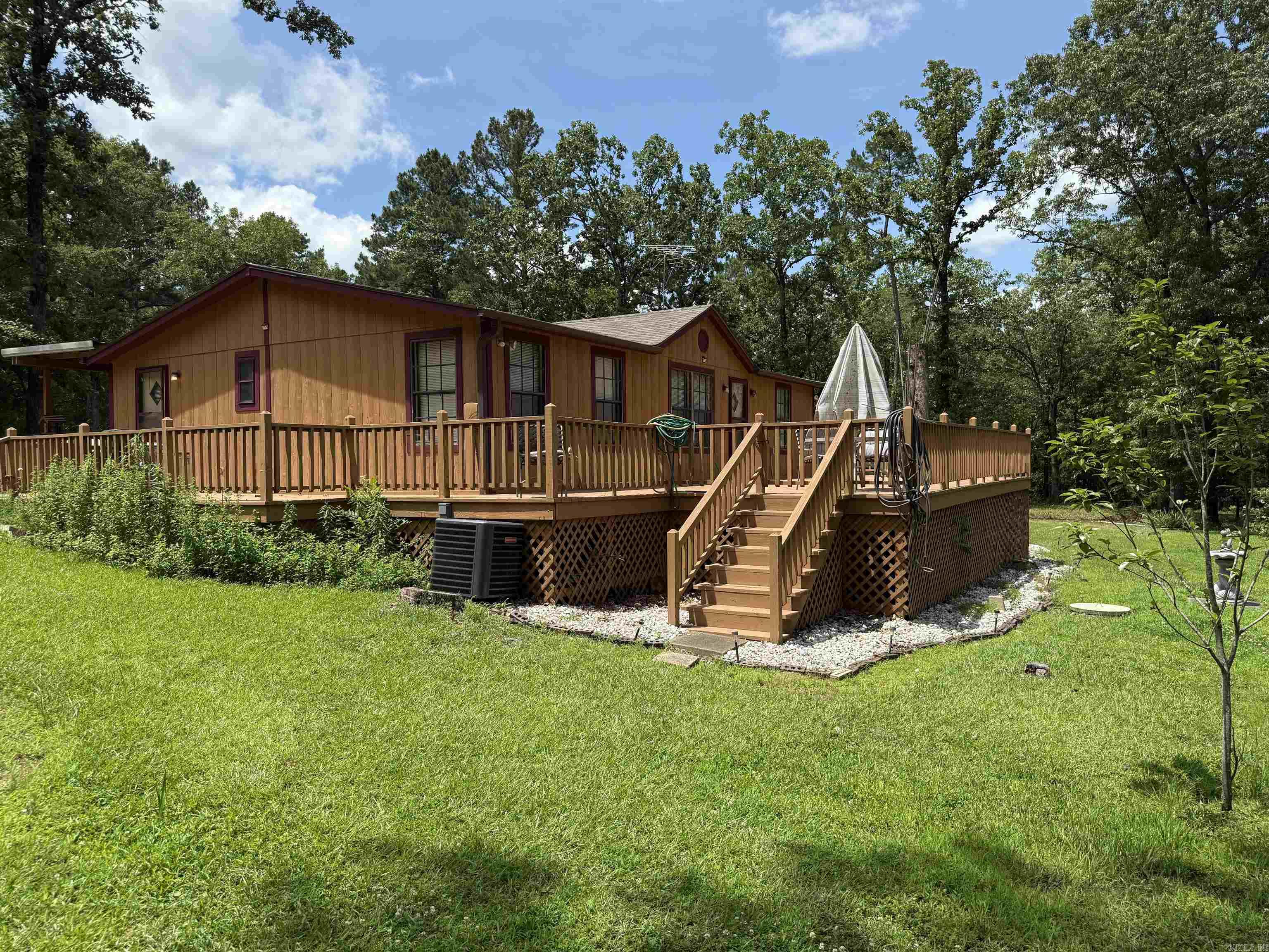 Charming little Retreat Nestled on a serene acre near Lake DeGray, this cozy 3 bedroom, 2-bathroom home offers the perfect blend of comfort and outdoor adventure, which creates an inviting atmosphere. Recently painted exterior & wrap around deck. Updates include new HVAC, roof, hot water heater, garbage disposal. All appliances stay including washer/dryer. Whole house propane 18kw Kohler generator. Lots of storage with 4 new tied-down storage sheds, 3 with power, one finished/insulated on interior, all placed on black-top, perfect mancave and she sheds! Stand alone carport. Fiber optic internet. All electric with both city and well water (currently on city). Partially fenced, yard has fruit trees nice shade trees, and gardening spot. Bismarck Schools. Sold as-is only.