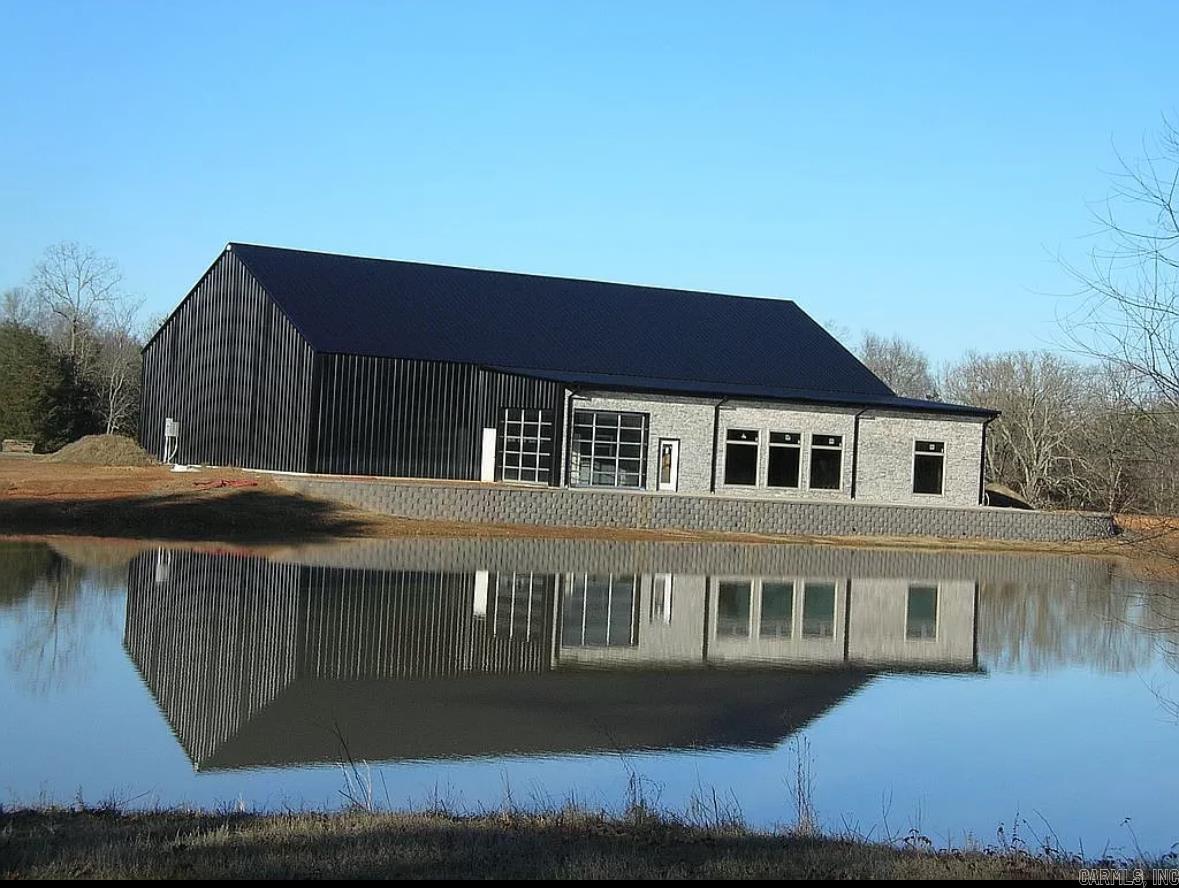 Custom Barndominium currently under construction. 6500 sqft (3200 sqft heated and cooled, 3300 sqft open shop space). 3 bedroom (plenty of room to add a few more), 4 bathroom, Large living room and kitchen with oversize windows overlooking the pond, nice man cave/indoor/outdoor kitchen with glass roll up doors, large all steel above ground safe room, 2 septic systems, huge indoor 50' bay for RV with full hookups, city water, natural gas all on 2 acres +/- outside city limits. Too many features to list, very unique.