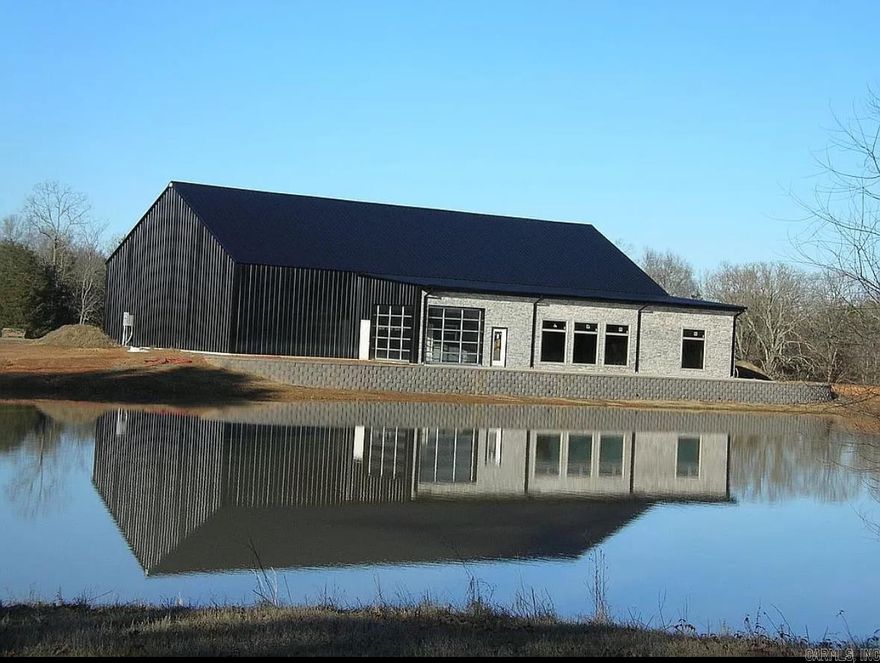 Custom Barndominium currently under construction. 6500 sqft (3200 sqft heated and cooled, 3300 sqft open shop space). 3 bedroom (plenty of room to add a few more), 4 bathroom, Large living room and kitchen with oversize windows overlooking the pond, nice man cave/indoor/outdoor kitchen with glass roll up doors, large all steel above ground safe room, 2 septic systems, huge indoor 50' bay for RV with full hookups, city water, natural gas all on 2 acres +/- outside city limits. Too many features to list, very unique.