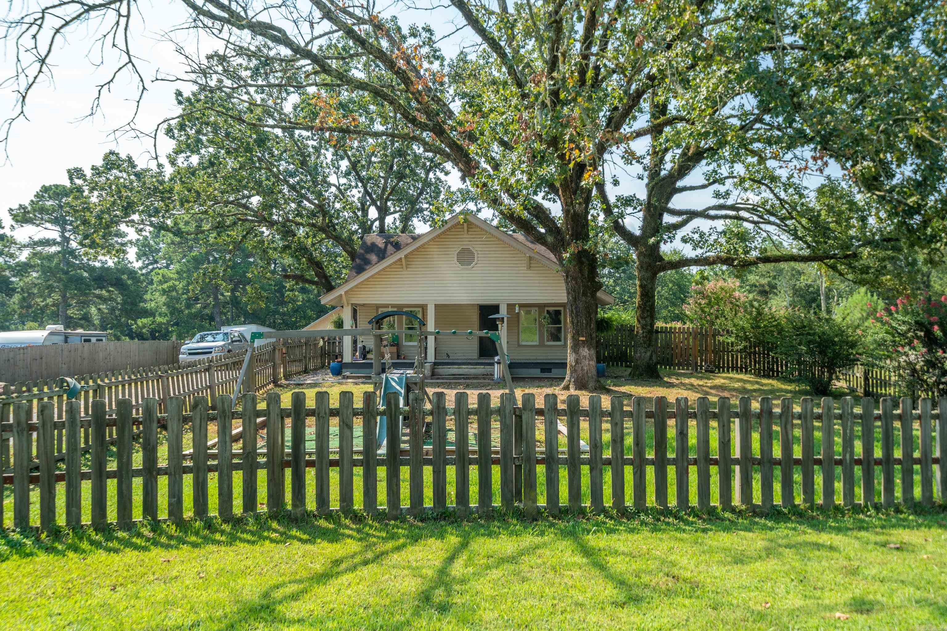 Vintage farm house plus a guest house on .99 acre. Farm house 1702 SF, guest house 881 SF. Farm house is 3/2, guest house is 1/2. Bonus room/bedroom upstairs in farm house. Wood burning fireplace in living/dining room. Recently updated guest bathroom. Master has bathroom attached. New Trane 4 ton Central heat & air in 2018. Farm house rewired in 2022, newer insulated windows. Fully fenced except driveway & parking. Guest home has metal roof, Central heat & air as well as gas space heater. Guest home has covered deck & patio. Outside city limits, LSSD. Needs your personal touches. Recent appraisal available upon request. Swing set does not convey, hot tub is negotiable. Buried propane tank not in use.