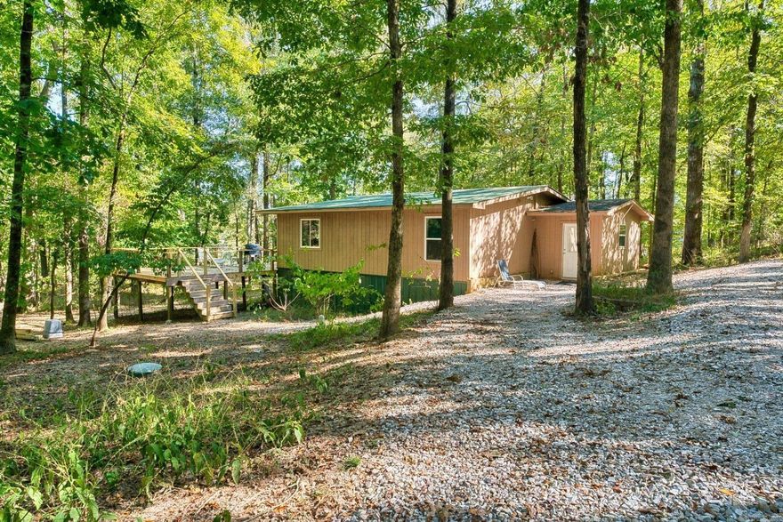 Nestled in a tranquil, 23 Acre wooded setting, this charming bungalow is the ultimate escape. Step inside to discover a cozy layout featuring 2 bedrooms, 1 bathroom, and a flexible bonus room that easily serves as a guest room, den, or home office. The true magic of this property lies outdoors. The expansive deck invites you to entertain, dine, or simply relax while soaking in the peaceful water views. A gentle path leads you to your private dock, offering direct access for boating, fishing, or simply enjoying the lakeside ambiance in an incredibly peaceful environment. For the enthusiast or entrepreneur, a massive 30x60 shop provides endless possibilities for a workshop, boat storage, or a creative studio. There is plenty of room to build additional homes or use your imagination, as it is outside of the city's jurisdiction. This is more than a home; it's a lifestyle. Secure your private slice of paradise today!