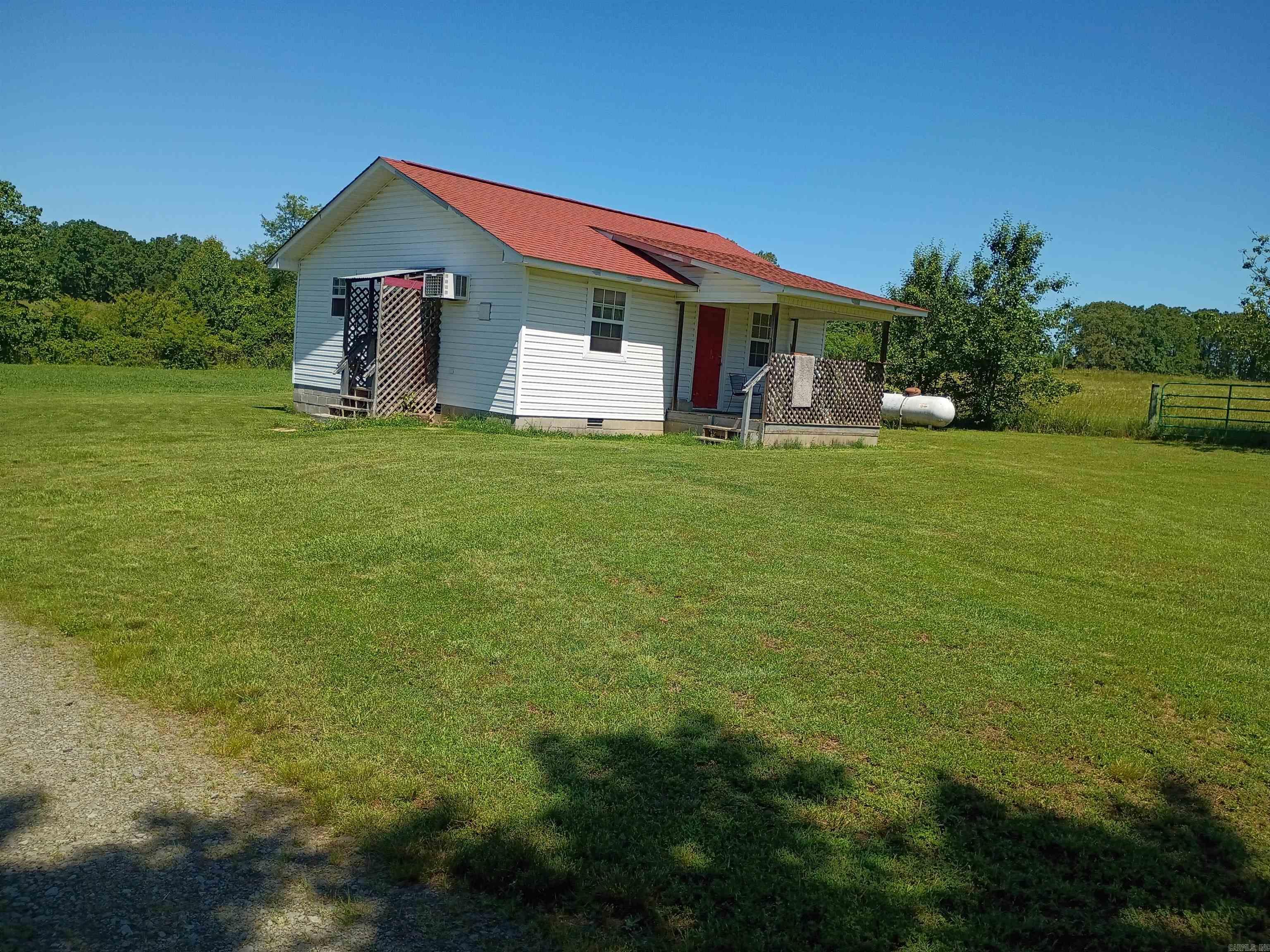 Nestled on 5 peaceful acres, this charming 1-bed, 1-bath cottage is a perfect country retreat. Enjoy tranquil sunrises from the east-facing front porch. Inside, find a cozy bedroom, full bath, and modern updates including a 1-year-old water heater and a 2017 roof. A storm shelter adds peace of mind. Outdoor features include 2 fenced acres with fruit trees—great for gardening or livestock—and 3 mowed acres ideal for hay, grazing, or expansion. A 10x16 shed with electricity offers extra storage or workspace, plus a carport for vehicle protection. Mature shade trees provide cool, relaxing spots throughout the day. Set on a quiet, low-traffic road, this property offers the privacy and serenity you've been seeking. Whether you’re looking for a weekend escape, full-time home, or hobby farm, this cozy cottage is ready to welcome you. Don’t miss this slice of country paradise!