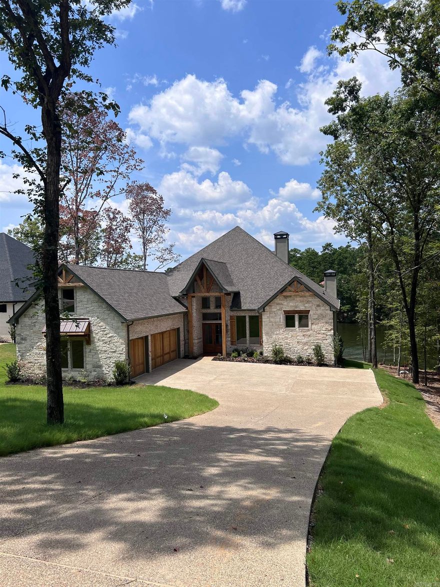 This home checks all the boxes: New Construction on Lake Hamilton, Deep Water and Expansive views, Highly Desired 7 South location and a Stunning Home with the appointments you are looking for. Beautiful wood ceilings and beams add charm to this open floorplan home that welcomes your family and guests.  Large granite island in the chef’s kitchen, with custom cabinets throughout. Three fireplaces add to the warmth and coziness of this lakeside retreat. The primary bedroom features a vaulted wood ceiling, fireplace, and private coffee bar. Custom His and Her closets with plenty of storage and built ins. The primary ensuite has a luxurious Roman Double Shower and his and hers vanities and a soaking tub. All bedrooms in the home are ensuite. The outdoor living area is covered and has a fantastic outdoor kitchen. This home has a boat dock permit that will transfer at closing. POA is currently being formed, no financial or dues amount have been established but developer had indicated it should be like Blue Herron POA. Estimated completion Spring 2024.
