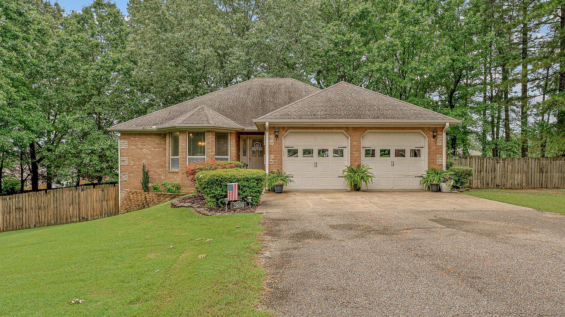 Situated on a spacious one-acre lot with mature shade trees, this beautifully maintained home offers a functional layout with thoughtful updates throughout. The main-level primary suite features a walk-in shower, relaxing soaker tub, dual sinks with dedicated vanity space, Corian countertops, and a generous walk-in closet. The upstairs living area is warm and welcoming, centered around a tile-surround fireplace with custom built-insāperfect for both everyday living and entertaining. Enjoy cooking in the kitchen, complete with stainless steel appliances, Corian countertops, a breakfast nook, and a formal dining room. An office nook is also conveniently located upstairs, ideal for remote work or study space. Downstairs, you'll find two additional bedrooms, a spacious second living area, a fully remodeled bathroom with granite countertops, and a kitchenetteāoffering great flexibility for guests or multi-generational living. Tile flooring runs throughout the lower level for easy maintenance and a clean, modern feel. Outside, enjoy a fenced yard, deck, and two separate patiosāplenty of space for outdoor gatherings, play, or peaceful mornings with coffee under the trees.
