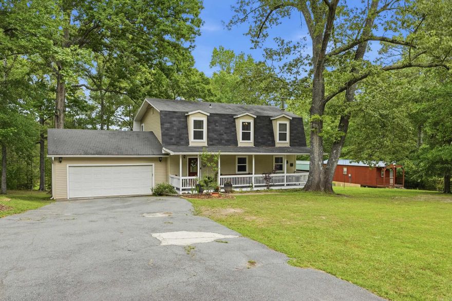 Welcome to a property that offers the best of both worlds—space, convenience, and a true sense of home. Situated on just over an acre providing a peaceful, tucked-away setting while still being just minutes from Arkansas’ only outlet shopping center, dining, and everyday amenities.  From the moment you arrive, the inviting country charm stands out. A large front porch sets the tone—perfect for quiet mornings or relaxing evenings. Step inside to a warm, comfortable layout that immediately feels like home.  Key updates have already been completed, including a newer roof and windows, offering peace of mind. The spacious primary suite features an en suite with two separate showers, adding both comfort and functionality. Outside, an oversized garage offers plenty of room for storage, hobbies, or workspace. The property also includes a detached accessory dwelling unit (ADU) with its own living area, bedroom, kitchen space, and full bathroom—ideal for guests or extended living arrangements. To top it off, a 12x20 storage building with electricity is ready for projects or additional storage. A rare combination of land, updates, versatility, and location—this treasure awaits its next owner.