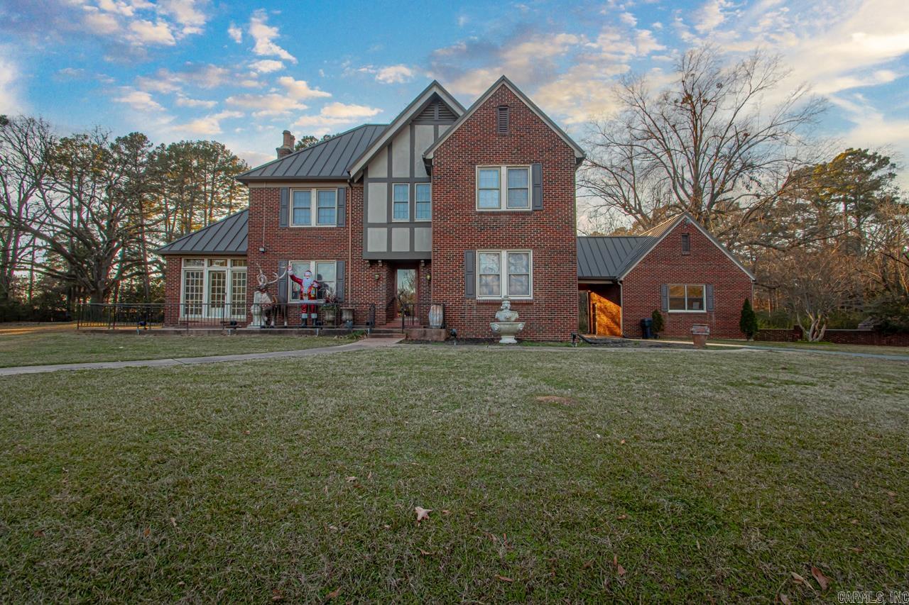 Exquisite two-story Tudor home with a rare blend of timeless charm and updated conveniences.  Featuring 3 bedrooms, 3 baths, formal dining and spacious living room, a cozy den, and 2 offices/ sunroom.  This historic home has Anderson windows, an updated kitchen, gas fireplace & original hardwood floors that exude warmth and character.  The high ceilings and intricate trim details further enhance the old-world charm of this remarkable property.. It also includes a 2 car garage, basement, and separate mother-in-law quarters/guest house, all set on 6 acres. This property has endless possibilities! This is your opportunity to own a piece of history, complemented by elegant architectural details and the serenity of expansive acreage. The guest house is 780 sq ft 1 bedroom 1 bath. New metal standing seam roof 2019