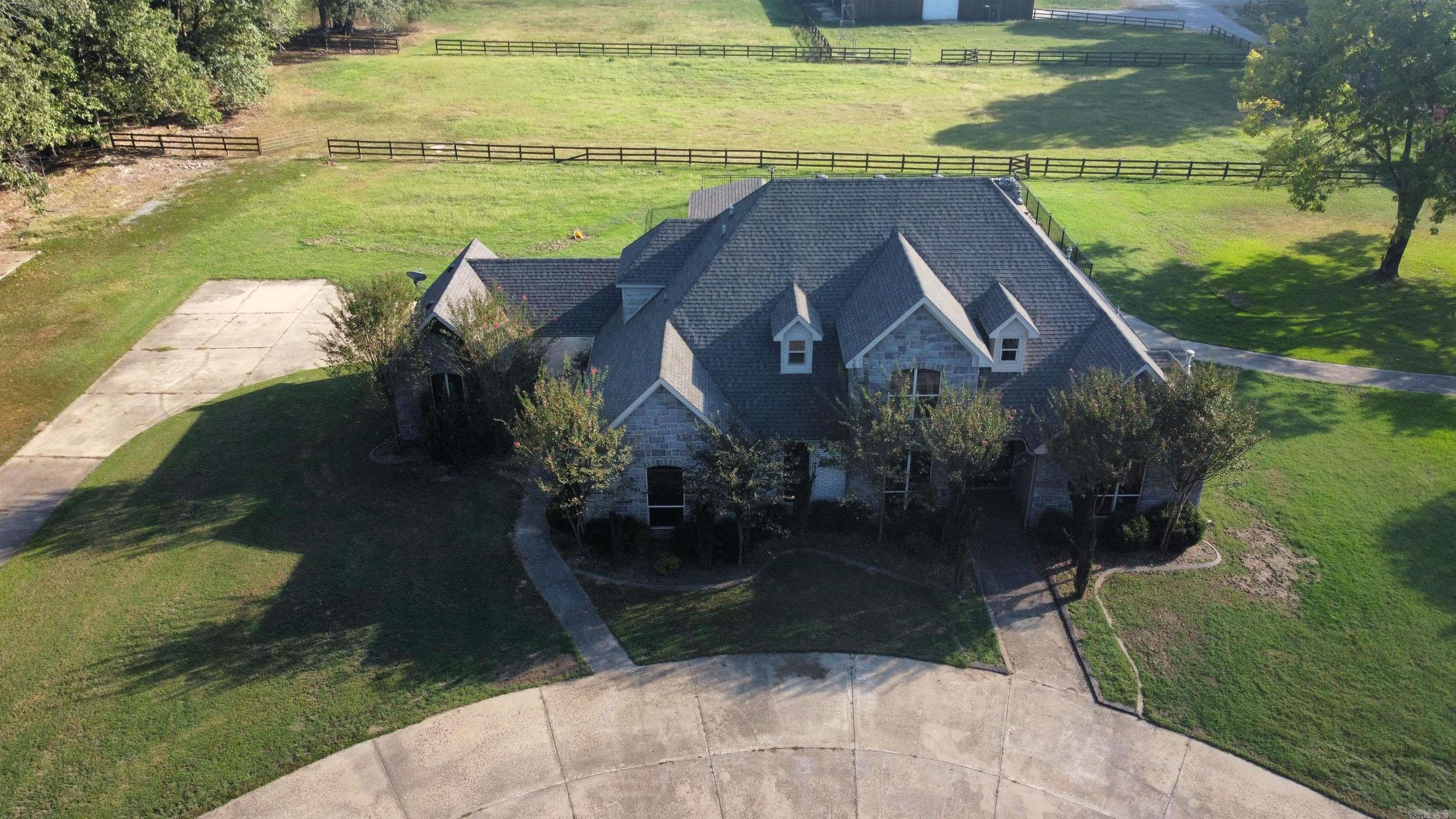 Horse lover's dream! Ranch in the middle of town! +/- 17.29 level acres with nice house and multiple impressive buildings. 5 bed 3.5 bath house with garage & separate office/garage. Large stable with multiple stalls, office, living quarters, entertainment area, fireplace, pull through or RV parking. Smaller barn with additional stalls & tack room. Arena with fencing, paddocks. Very unique property close to I30 & I430 interchange. Recent foreclosure, bank owned REO. Sold as is, no disclosure. See agent remarks.