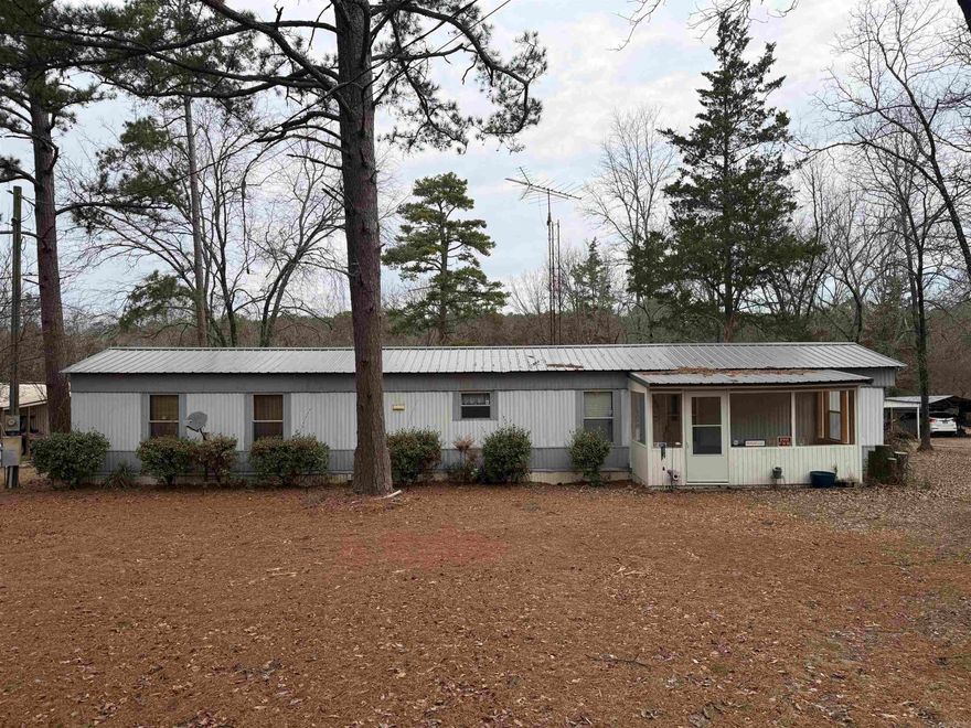 Just one mile from the boat ramp at Greers Ferry Lake in Tumbling Shoals, this property offers the kind of setting buyers look for when they want a true lake-area retreat with room to breathe. Situated on approximately .63 acres, the layout is practical and welcoming. From the enclosed front porch, you enter the living room, with the kitchen and dining combo positioned to the left. A bonus room off the kitchen provides flexible use, while the primary suite is located beyond the kitchen with a convenient laundry closet in between. To the right of the entry are the guest bathroom and second bedroom. The back door opens to a large covered deck overlooking the backyard—ideal for relaxing after a day on the water. A metal roof was replaced in 2023, and recent updates include new flooring in the primary bath and new toilets. A boat house is on site, and most furnishings will remain. Sold as-is. Boat in boat house will be removed. Seller will remove ONLY sentimental items from property up to closing. Inspections for buyer knowledge only as Seller will not be making any repairs.