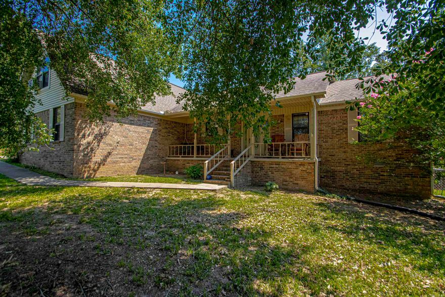 Country Setting with lots of privacy. 3 Bedrooms, 2 full bath with bonus room. This home features a beautiful open kitchen, living, and dining area. Split bedroom plan with Large master with access to back deck. Master bath features separate jacuzzi tub/shower. Large walk in closet. 2 additional bedrooms are good size with double closets. Nice laundry room with built in iron board. Large linen closet inside the laundry with great storage. Large storage building. 2 car metal carport with added storage area. 2 car garage. All on approximately 1 acre. All brick home with fenced area in backyard. Schedule your viewing today. See Remarks.