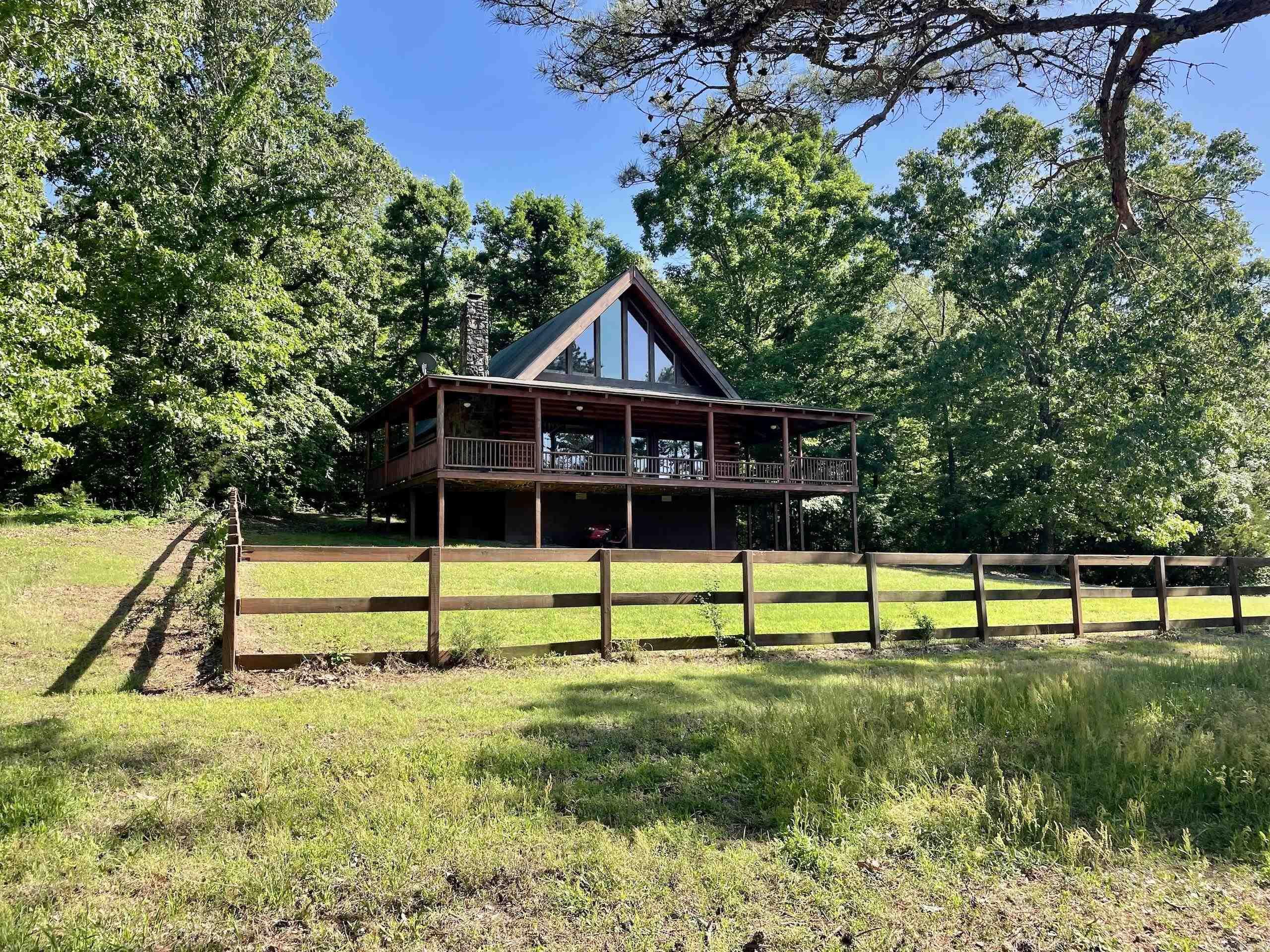 This custom-built 2005 log home offers rustic charm and thoughtful design on a truly exceptional piece of land. With two bedrooms, 2.5 baths, and 1,677 sq. ft. of interior space, the home features a massive native stone, wood-burning fireplace and an expansive 809 sq. ft. wraparound porch. Equestrians will appreciate the impressive 48' x 78' four-stall horse barn with electricity, well, and water, and the fenced and cross-fenced 24 acres of open pasture, designed for rotational grazing. The property has served as a safe haven for rescue horses and is enrolled in an NRCS conservation plan, ensuring its land and water are cared for with the utmost integrity. Thereās a .16-acre secondary pond and over half a mile of the beautiful North Fork of the Cadron Creek flowing through the property. Rural County water services the main house with two additional drilled wells. The remaining acreage is covered in mature timber creating a thriving habitat for wildlife. The property is also close to world-class trout fishing on the Little Red River and endless recreational opportunities. House plans and NRCS conservation plan are available. Mineral rights do not convey.