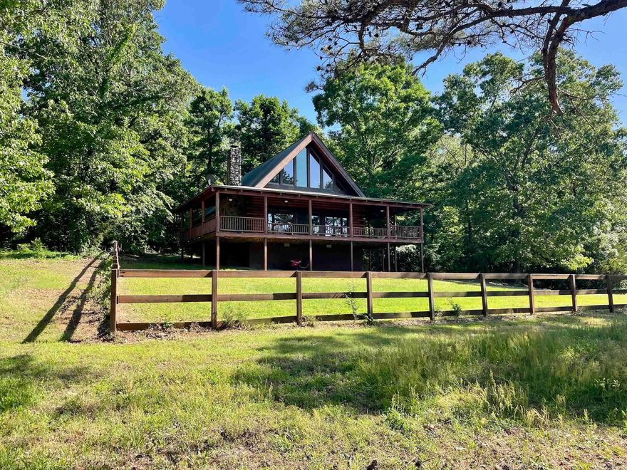 This custom-built 2005 log home offers rustic charm and thoughtful design on a truly exceptional piece of land. With two bedrooms, 2.5 baths, and 1,677 sq. ft. of interior space, the home features a massive native stone, wood-burning fireplace and an expansive 809 sq. ft. wraparound porch. Equestrians will appreciate the impressive 48' x 78' four-stall horse barn with electricity, well, and water, and the fenced and cross-fenced 24 acres of open pasture, designed for rotational grazing. The property has served as a safe haven for rescue horses and is enrolled in an NRCS conservation plan, ensuring its land and water are cared for with the utmost integrity. There’s a .16-acre secondary pond and over half a mile of the beautiful North Fork of the Cadron Creek flowing through the property. Rural County water services the main house with two additional drilled wells. The remaining acreage is covered in mature timber creating a thriving habitat for wildlife. The property is also close to world-class trout fishing on the Little Red River and endless recreational opportunities. House plans and NRCS conservation plan are available. Mineral rights do not convey.