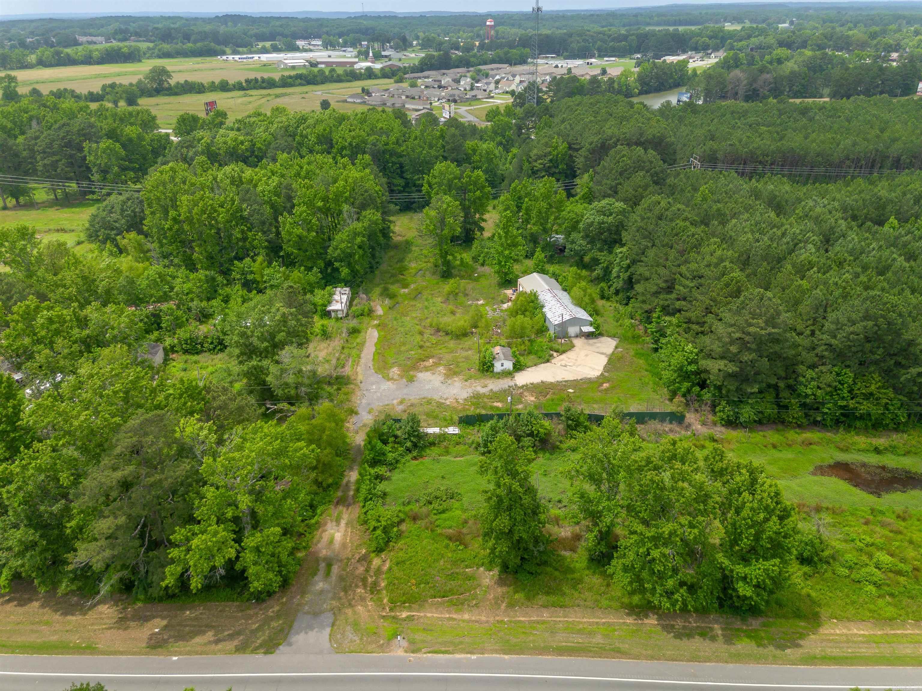 Located on a high-visibility stretch of Highway 367 S, this 5-acre property offers unique potential for both residential and commercial use. The front parcel is zoned C2 commercial, making it ideal for business opportunities, while the larger rear parcel is zoned R1 multi-use residential—offering flexibility for future development or expansion. An easement has been granted, providing convenient access from the front commercial parcel to the rear residential section. This setup creates a seamless opportunity for a live/work setup, rental units, storage, or mixed-use investment.