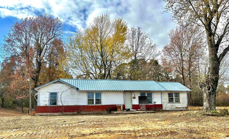 This property features 4.84 acres of mostly cleared land with highway frontage.  Public utilities are available. There are no restrictions so you could use the pond for livestock or personal use. Multiple building sites for your new home! Need extra storage? There is a shed with a concrete floor located behind the house. SOLD AS IS. Owner financing is possible. Schedule a showing today!
