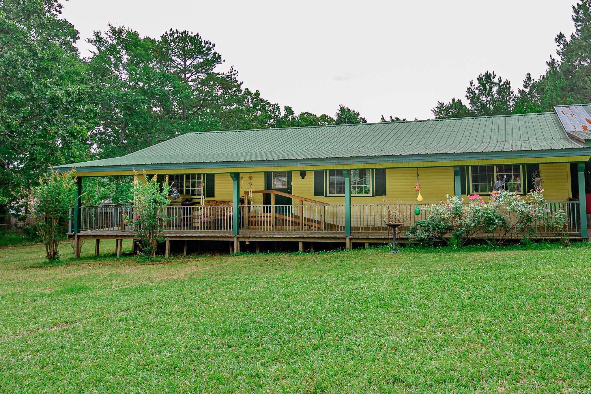 Home nestled just on the out skirts of Mena in private location. Come home to the country two minutes from Post Office, Hospital, Shopping just off of paved road. Three bedroom two full bath home, spacious living area with large windows, kitchen with side dining area offering patio doors to overlook back yard and deck area. Home has full covered porch and deck, attached oversized carport, large shop. Close to Ouachita Mountain, ATV trails, bike trails, creeks, rivers.