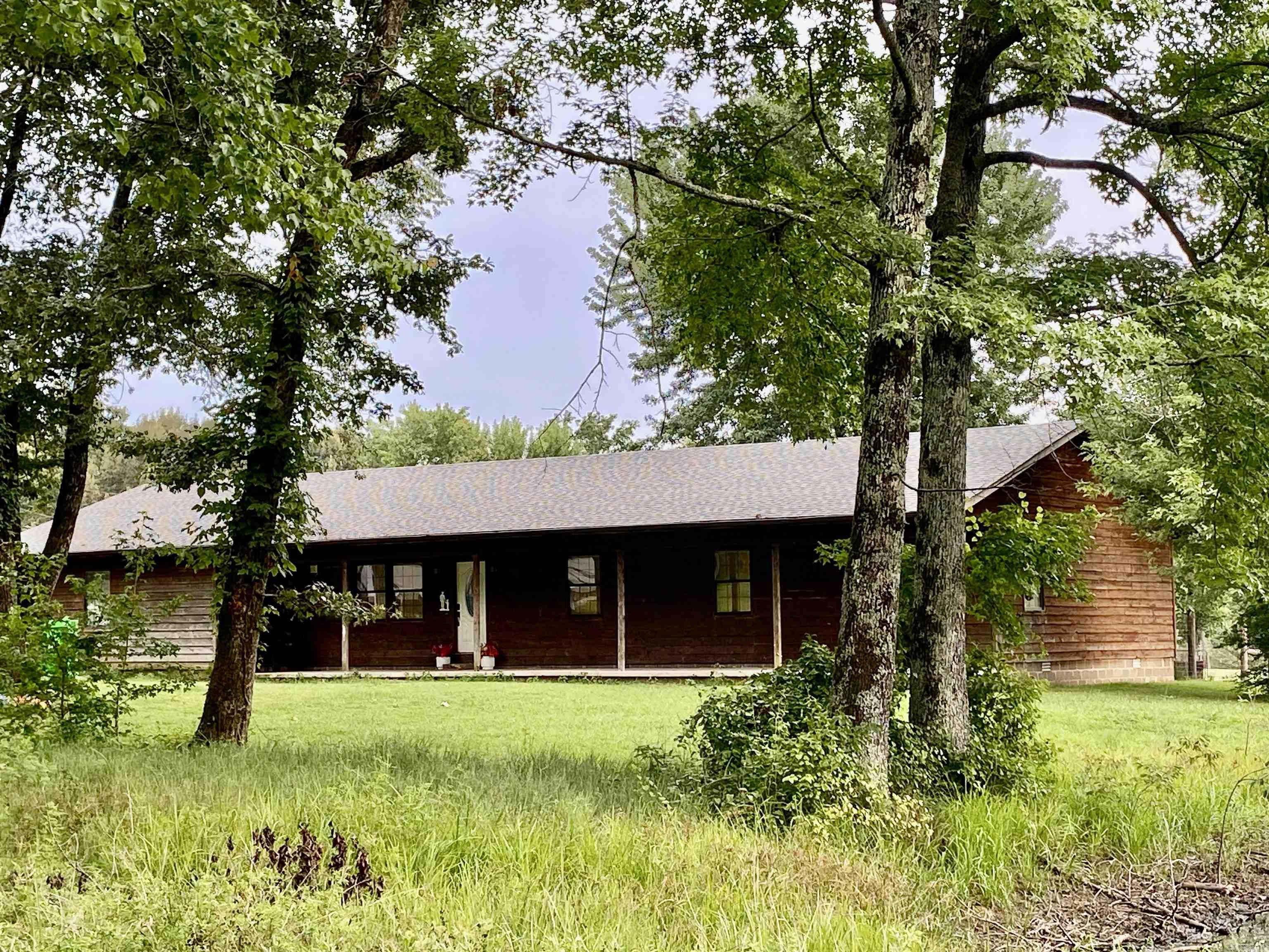 Charming country home with wood siding, situated on 2 acres of lush, park-like lawn surrounded by large shade trees and a small fish pond. Just minutes from Lake Ludwig and the Ozark National Forest, this peaceful property offers privacy with few nearby neighbors. Inside, youāll find a spacious eat-in kitchen with stainless steel appliances, a generous living area, and cedar-lined closets. The layout includes a dedicated office or potential 4th bedroom, and a primary suite featuring double vanities and two walk-in closets. Enjoy outdoor living from the welcoming front porch to the rear sun deck, plus a fenced area perfect for pets. A 12x24 storage building, new roof (2023), and new AC (2020) complete this serene and well-equipped retreat.