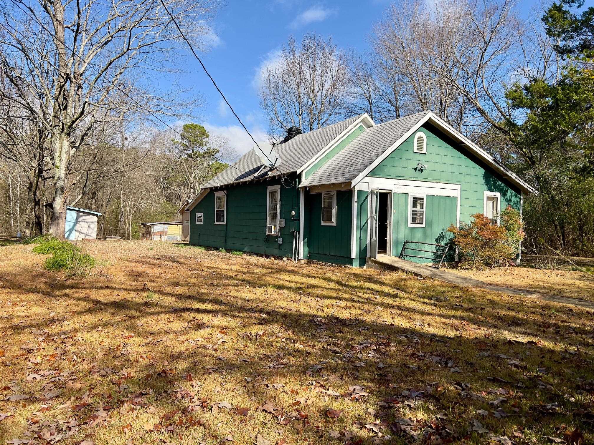 Make this home your own! New subflooring just installed in rooms pictured, home is livable but considered a fixer upper. Property can be purchased "As Is" or owner will remodel for an additional fee. Home is nestled on a beautiful 1.194 acres with large scattered trees. There is a nice shop/storage building that could easily be converted into a guest tiny house. Beautiful land allowing room for a new build on property. Close to medical center, shopping, post office, Ouachita mountains, public swimming pool.
