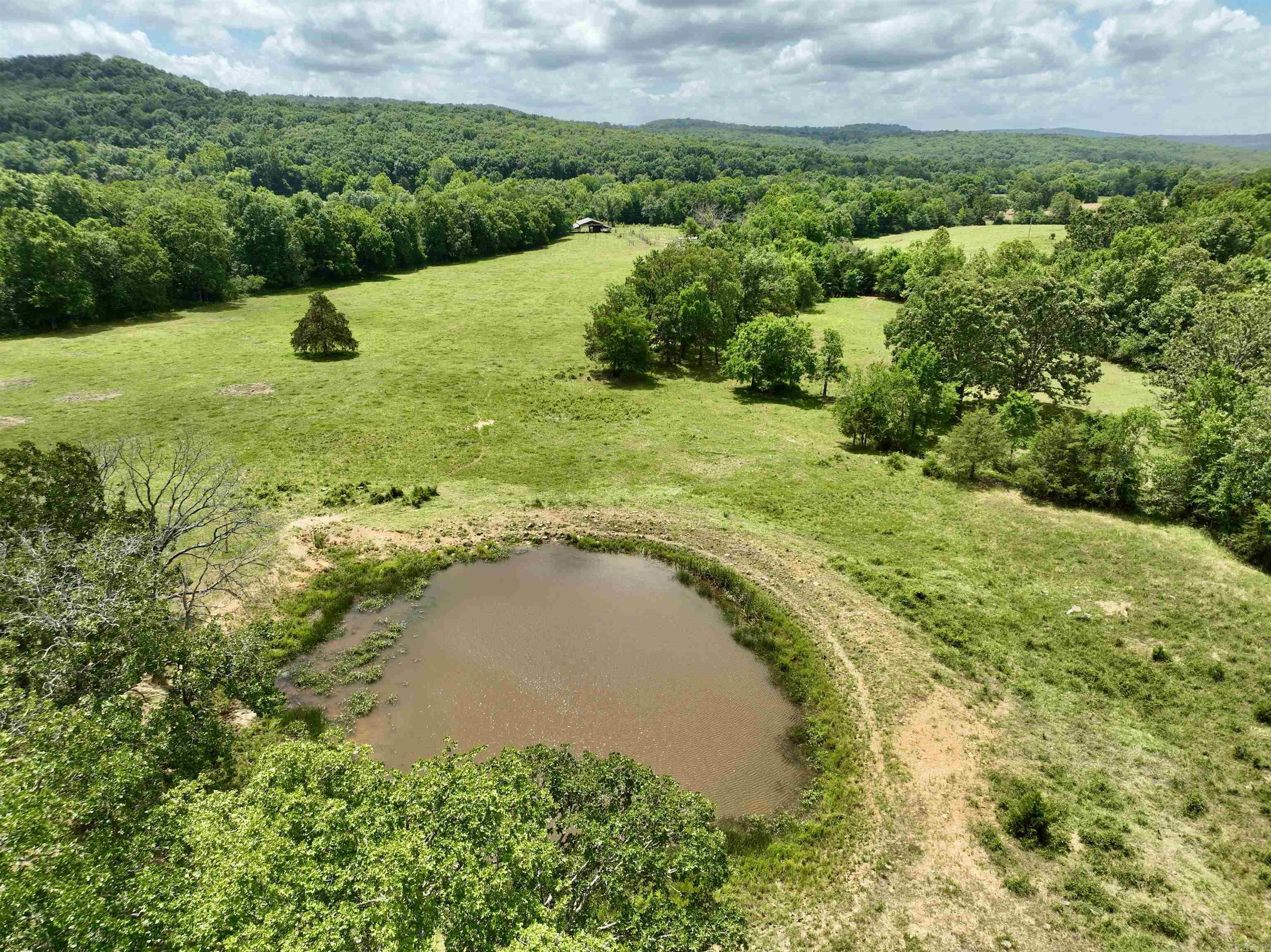 Located in the scenic Ozarks, this exceptional cattle and recreational ranch offers a prime location with multiple access points, just 10 miles from Elkins and 18 miles from Fayetteville. This working cattle ranch is fully equipped with fencing and cross-fencing, ensuring efficient livestock management. Essential utilities, including electric and rural water, are conveniently available at the road. The property boasts functional infrastructure with a pole barn, loafing shed, corral, and working pens, all designed to support your ranching operations. The land presents a harmonious blend of large open pastures, mature hardwood timber, and recently cleared areas with undergrowth, providing diverse habitats and land use opportunities. A substantial pond caters to all your watering needs, year-round, ensuring a reliable water source. With numerous potential building sites, you can enjoy breathtaking panoramic views and the opportunity to develop your dream home or multiple dwellings, as the property has the potential to be subdivided.