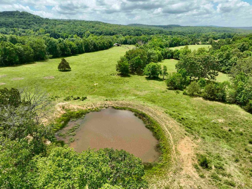 Located in the scenic Ozarks, this exceptional cattle and recreational ranch offers a prime location with multiple access points, just 10 miles from Elkins and 18 miles from Fayetteville. This working cattle ranch is fully equipped with fencing and cross-fencing, ensuring efficient livestock management. Essential utilities, including electric and rural water, are conveniently available at the road. The property boasts functional infrastructure with a pole barn, loafing shed, corral, and working pens, all designed to support your ranching operations. The land presents a harmonious blend of large open pastures, mature hardwood timber, and recently cleared areas with undergrowth, providing diverse habitats and land use opportunities. A substantial pond caters to all your watering needs, year-round, ensuring a reliable water source. With numerous potential building sites, you can enjoy breathtaking panoramic views and the opportunity to develop your dream home or multiple dwellings, as the property has the potential to be subdivided.