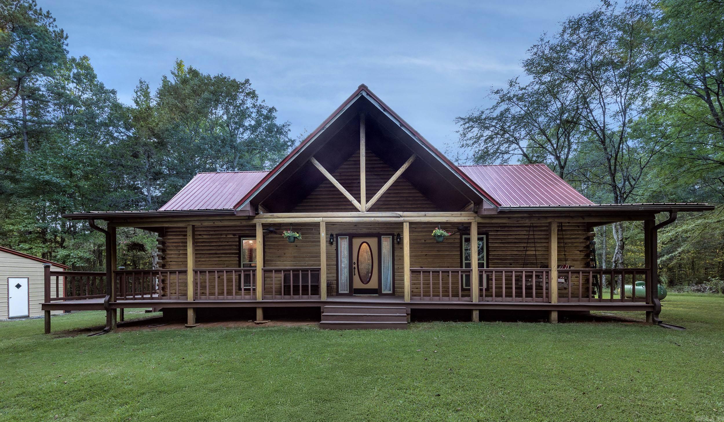 Nestled on a private 5-acre wooded escape featuring valuable hardwood timber, country paradise just 10 minutes from Cabot, this charming 3-bedroom, 2.5-bath log home is perfect for family living. The large living room features a vaulted ceiling, a giant rock fireplace, and an abundance of natural light, while the kitchen boasts new granite countertops, ample cabinetry, a pantry, a breakfast bar, and space for a large family table. The big master bedroom opens via double glass doors to the expansive wrap-around deck and features a master bath with double vanities, a large shower, and a closet, with two additional bedrooms located upstairs. Recent updates include a metal roof and newer HVAC, and the property also features an above-ground pool and a new detached 2-car garage/shop with additional parking. The land has been thoughtfully enhanced with thinned trees for both privacy and a more open feel, and the newly grassed area off the front covered porch creates a perfect spot for play, completing this idyllic country retreat. AGRNTS SEE REMARKS