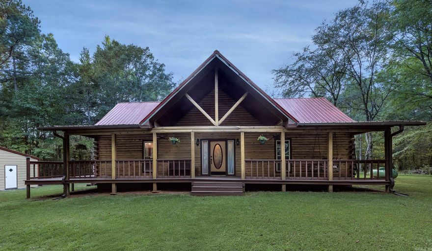 Nestled on a private 5-acre wooded escape featuring valuable hardwood timber, country paradise just 10 minutes from Cabot, this charming 3-bedroom, 2.5-bath log home is perfect for family living. The large living room features a vaulted ceiling, a giant rock fireplace, and an abundance of natural light, while the kitchen boasts new granite countertops, ample cabinetry, a pantry, a breakfast bar, and space for a large family table. The big master bedroom opens via double glass doors to the expansive wrap-around deck and features a master bath with double vanities, a large shower, and a closet, with two additional bedrooms located upstairs. Recent updates include a metal roof and newer HVAC, and the property also features an above-ground pool and a new detached 2-car garage/shop with additional parking. The land has been thoughtfully enhanced with thinned trees for both privacy and a more open feel, and the newly grassed area off the front covered porch creates a perfect spot for play, completing this idyllic country retreat.  AGRNTS SEE REMARKS