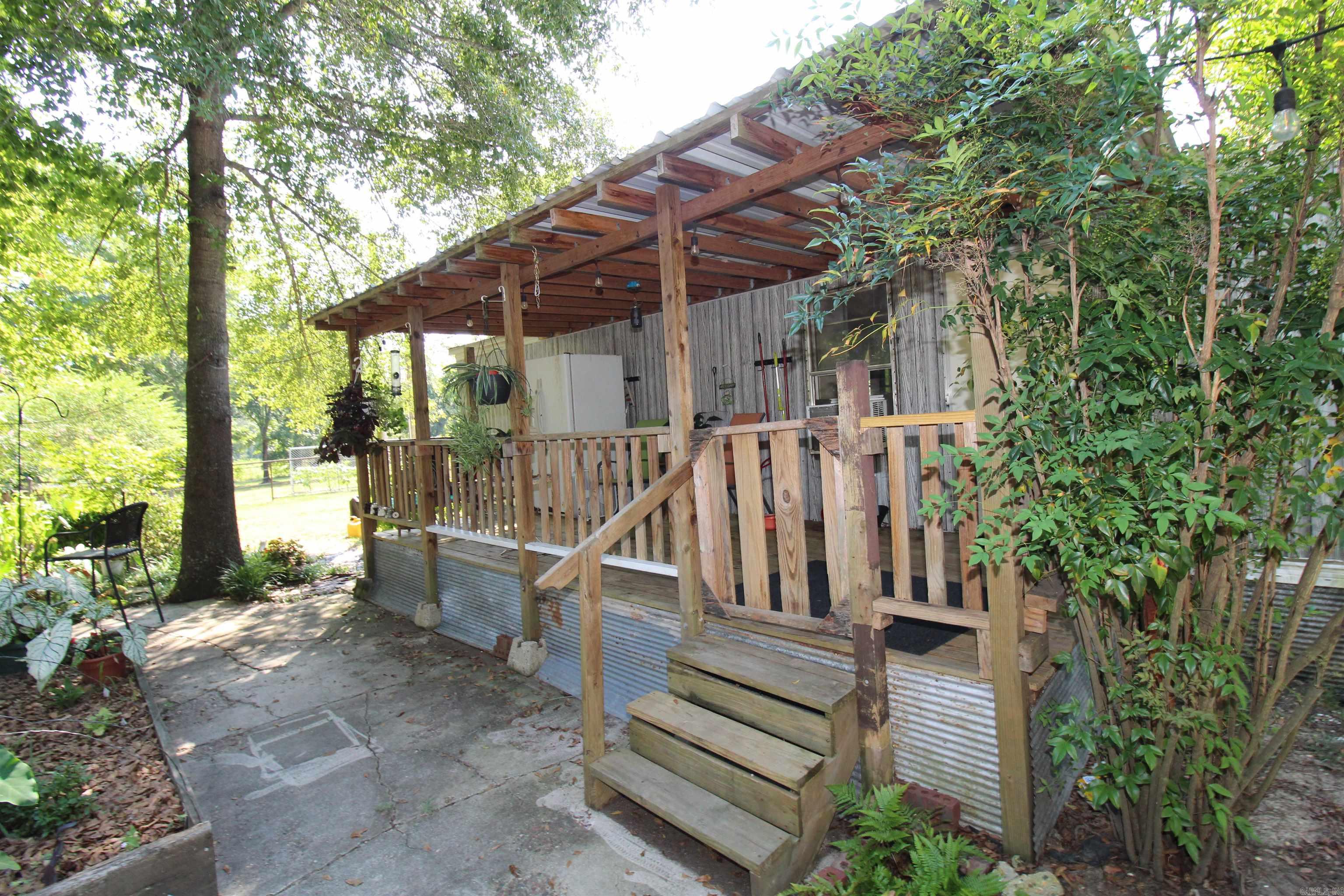 Original owner home and the seller has the mobile home title in hand*roof 2 years old*water heater 2021*new commode*several outbuildings including a nice one stall barn*all outbuildings have electricity*septic 2017*well water and public water on the property*beautifully landscaped*beautiful trees including a huge pecan tree*Koi pond*huge deck on back*nice front porch*convenient to Benton*such a cute place*the range, dryer/washer and two refrigerator convey*will have to be cash or an in-house conventional loan for financing*