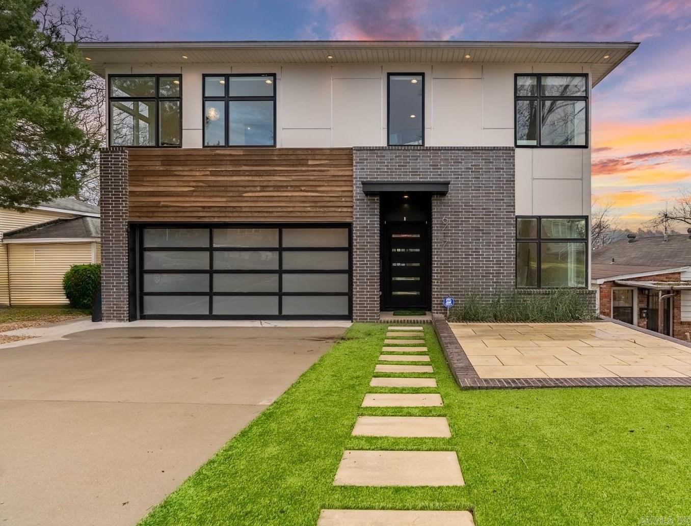 Stunning modern home custom built by Bill Parkinson in 2019 with incredible design elements. The exterior features Hardie backer board siding, large sleek windows, wood accents and brick. Main living area has tall ceilings, bookshelves with storage, all open to the fabulous kitchen with top notch appliances. Living area overlooks a screen porch that has an accordion door entrance. The primary bedroom is on the main level with gorgeous bath: double vanity, sleek tub and walk in shower. Two walk in closets (one is HUGE!!). Also on main level is a stylish half bath, office with closet storage. Adjacent to garage entrance and laundry is great mud room area, wonderful pantry and interior dog kennel for larger dogs. Upstairs are two ensuite bedrooms, one bath opening to the hallway to service the third large bedroom. Exercise room or upstairs office. Outdoors features synthetic grass complete with a putting green, front patio and a storm shelter under the house. Sleek interiors, an open floor plan, clean lines, large windows and tall ceilings give this home an airy feeling.