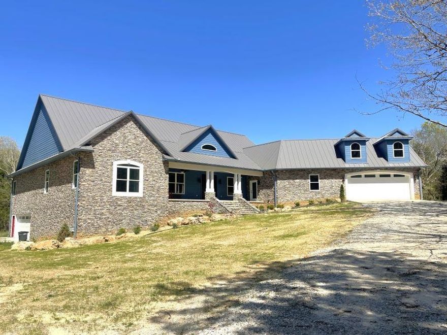 After entering the private gate, the driveway takes you through the woods, and down to your secluded paradise! This home has beautiful stone and siding on the exterior, a double-sided garage on the main level, a garage to the basement, a beautiful front porch, and a lovely deck on the back.  The interior of the home includes everything that you could possibly wish for...a large kitchen feauturing an oversized stove, double ovens, tons of cabinets, quartz countertops, two islands, and an ice machine.  The living area includes a beautiful fireplace and accordion glass doors that lead out to the deck. The master bedroom is bigger than most living rooms, and the bathroom right off of it is amazing...heating rack for the towels, double sink vanity, and a closet so big that it has it's own dresser right in the middle! The semi-finished basement is approximately 3419 sq ft, with some partitions already up dividing several rooms, plus a bathroom. The small creek on the property is very pretty to just sit and watch, or get your feet wet on a hot day. There isn't an inch of this home that isn't impressive! Once you see it, you'll never want to leave!