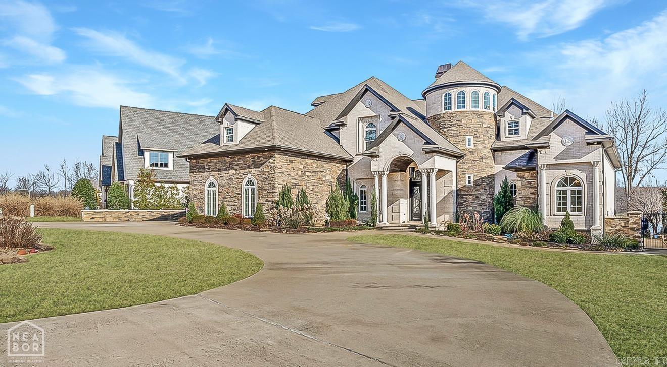 Welcome to 2064 Sloan Lake Dr. an exquisite 5 bed, 6.5 bath custom home in Jonesboro's prestigious Sloan Lake Estates. This 6042 +/- sq. ft. estate sits on 0.66 +/- acres with stunning views of the lake and saltwater pool. Inside, a grand two story foyer and spiral staircase lead to an open formal living area. The formal living features a soaring fireplace and floor to ceiling windows. The gourmet kitchen features custom cabinetry, glass tile backsplash, high end appliances, a wet bar, and walk in pantry. The main level primary suite includes a private balcony, spa like bathroom, and saferoom style walk in closet. Upstairs are three ensuite bedrooms, a media room, and a fifth bedroom. The covered patio with outdoor kitchen, gas fireplace, and poolside bath is ideal for entertaining. Built in 2017 with a 3 car garage, this home blends luxury, space, and lakeside living in one of the areas most coveted communities.
