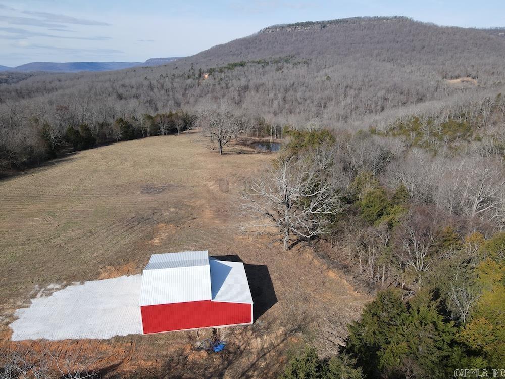 This unique property offers a stunning combination of rare features and extreme convenience. Located just minutes from Harrison, AR, Dogpatch USA, and the Buffalo National River, it fronts a paved county roadāno long gravel drives here! The land is rich with natural beauty, including caves, springs, waterfalls, and rock outcroppings. The unfinished cabin is framed for a 2-bedroom, 1-bath layout, with utilities like city water and electricity already connected. Enjoy panoramic views of Cone Point Mountain, a large pond, and a lush pasture teeming with wildlife. The impressive road system winds through the propertyās diverse terrain, including hardwood forests, creek beds, and native boulders. Explore the caves, waterfalls, and crystal-clear springs, or hike to bluff sections with flowing water. The area is also home to abundant deer, turkey, and even black bears, making it perfect for hunting. This is a once-in-a-lifetime opportunity to own a truly special Ozarks treasure!