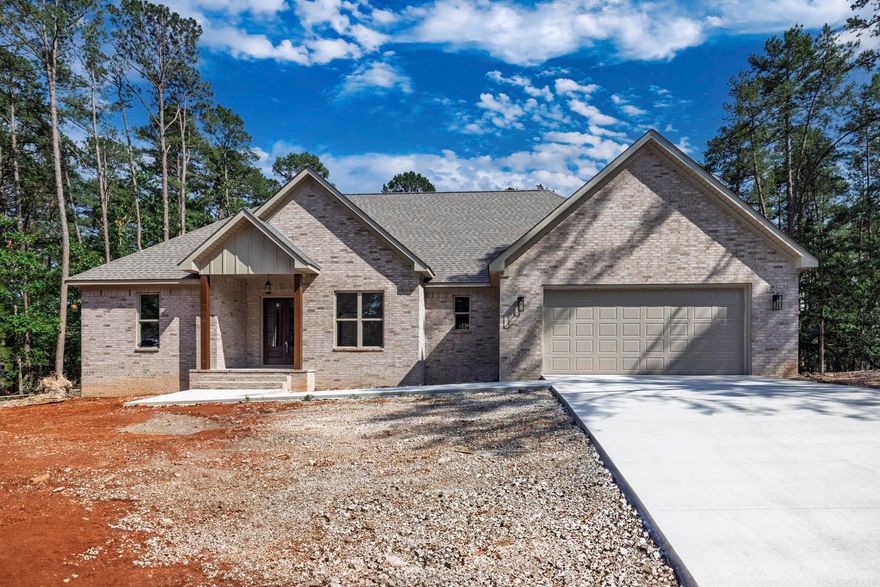 Brand new 2398 square foot home on lovely lot. Trees surround this lovely home with no homes behind. Spacious open floor plan gives you a perfect entertaining area with living, dining and kitchen all connected. You will not be isolated in the kitchen while the family enjoys visiting. Kitchen features a large island and large pantry for your convenience. White cabinetry and counters are an elegant white quartz. Living room opens to an oversized concrete deck perfect for outdoor Village living. Primary bedroom with walk in closet and bath with soaking tub and separate shower. Living area and all bedrooms have a very nice neutral LVP for easy living and low upkeep. Baths feature tile flooring and tub. Three additional  bedrooms complete this modern floor plan. Fourth bedroom would make an excellent office or computer room. Taxes are based on vacant lot. Interior pictures are of recent homes completed by builder. Hot Springs Village boasts 9 golf courses, 11 lakes, pickleball, hiking trails, white sand beach, tennis, fitness center and much more. HSV has one time $2000 buy in for new residents.